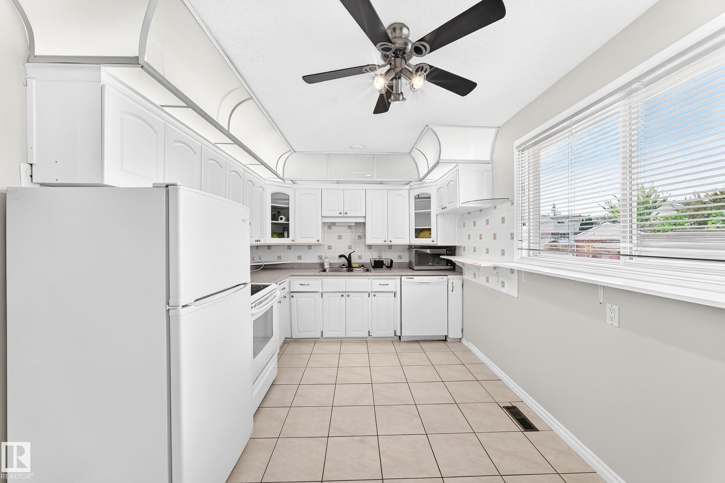 Kitchen featuring white cabinetry, tile flooring, white appliances, and a ceiling fan with integrated lighting - 44 Habitat Crescent Nw, Edmonton, AB