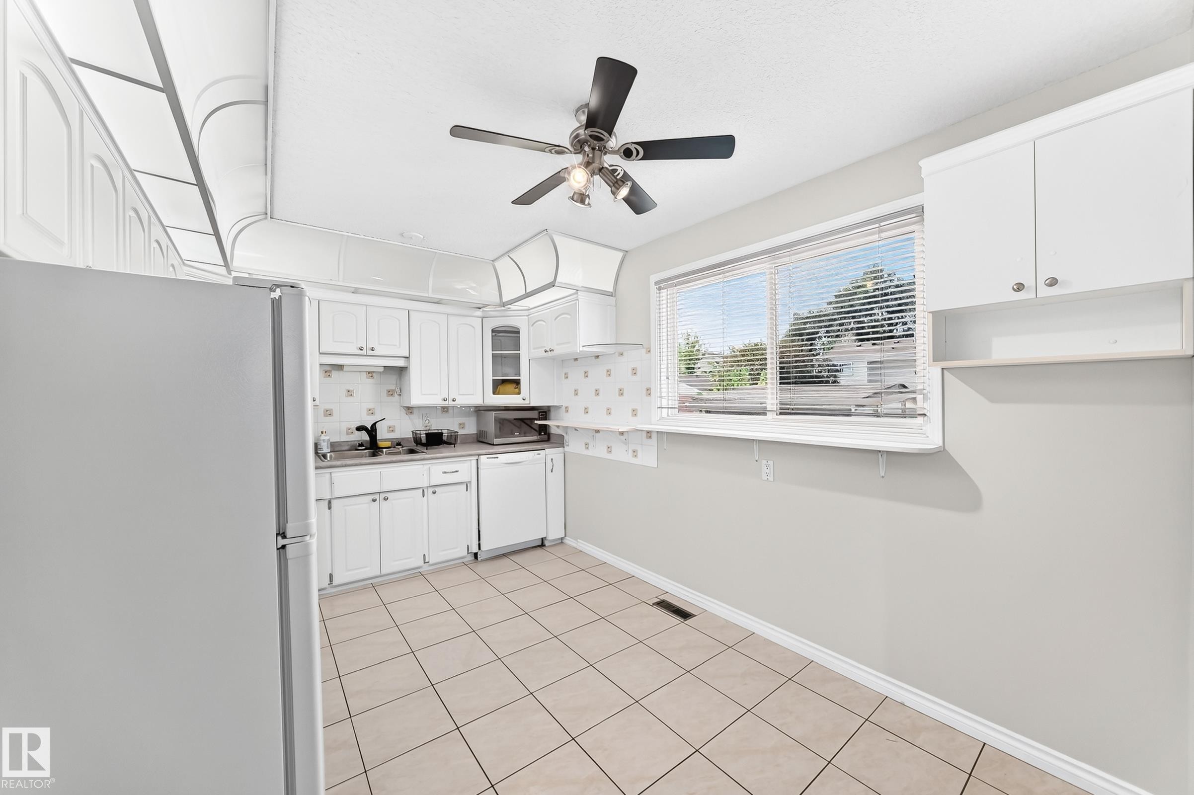 White cabinetry, tile flooring, ceiling fan, and a window with blinds - 44 Habitat Crescent Nw, Edmonton, AB