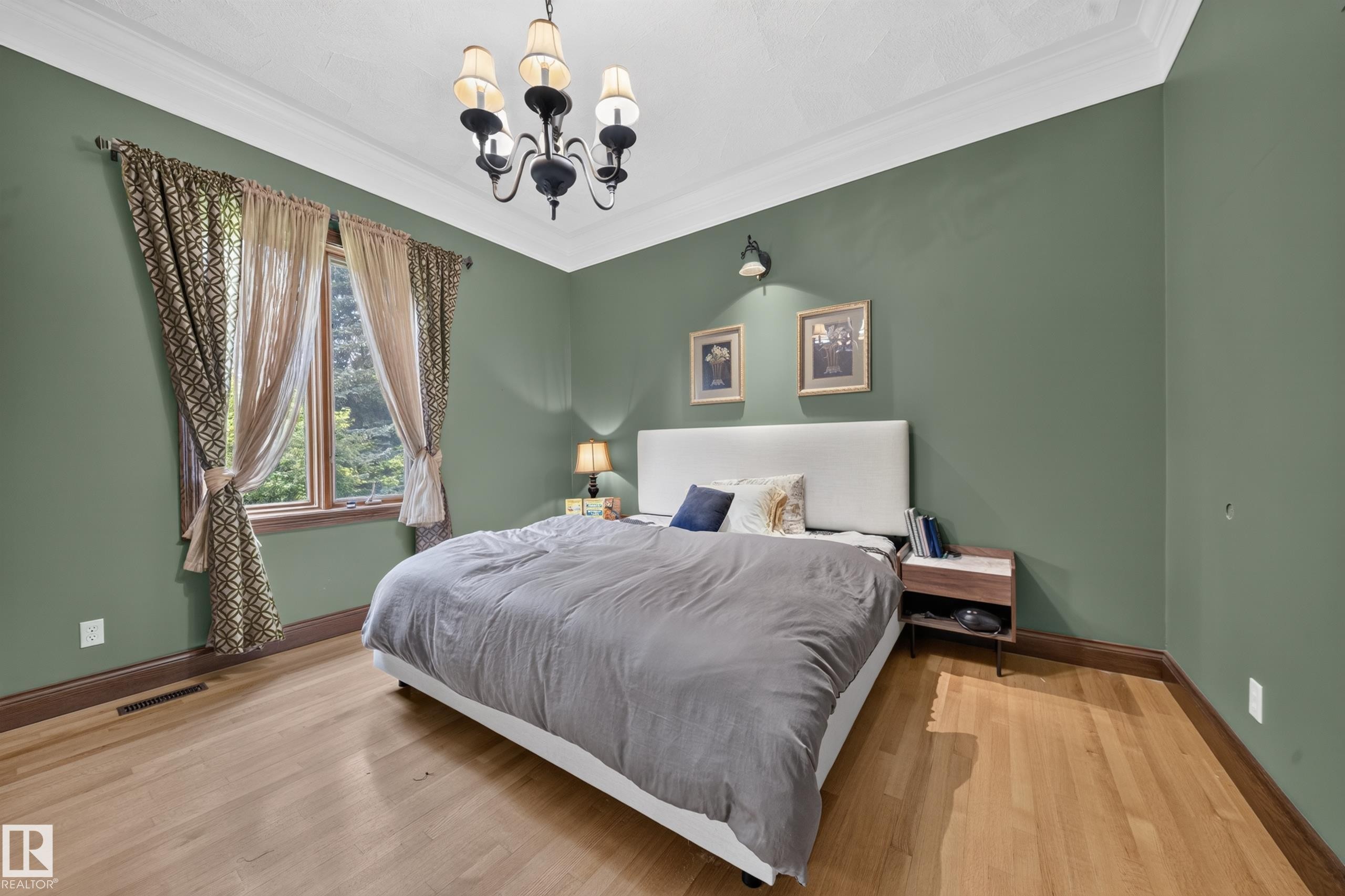 Hardwood flooring, crown molding, a decorative ceiling, a window with trim, and a chandelier - 719 65 Ave Nw, Edmonton, AB