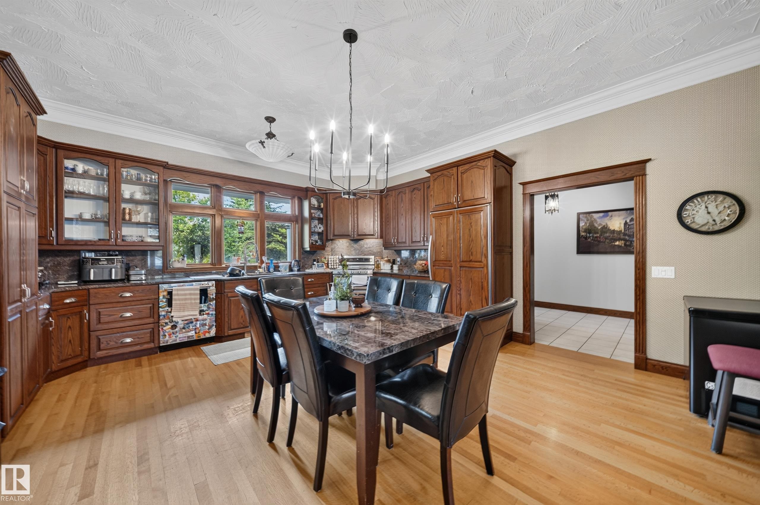 Hardwood flooring throughout, custom wood cabinetry, granite countertops, and large picture windows - 719 65 Ave Nw, Edmonton, AB