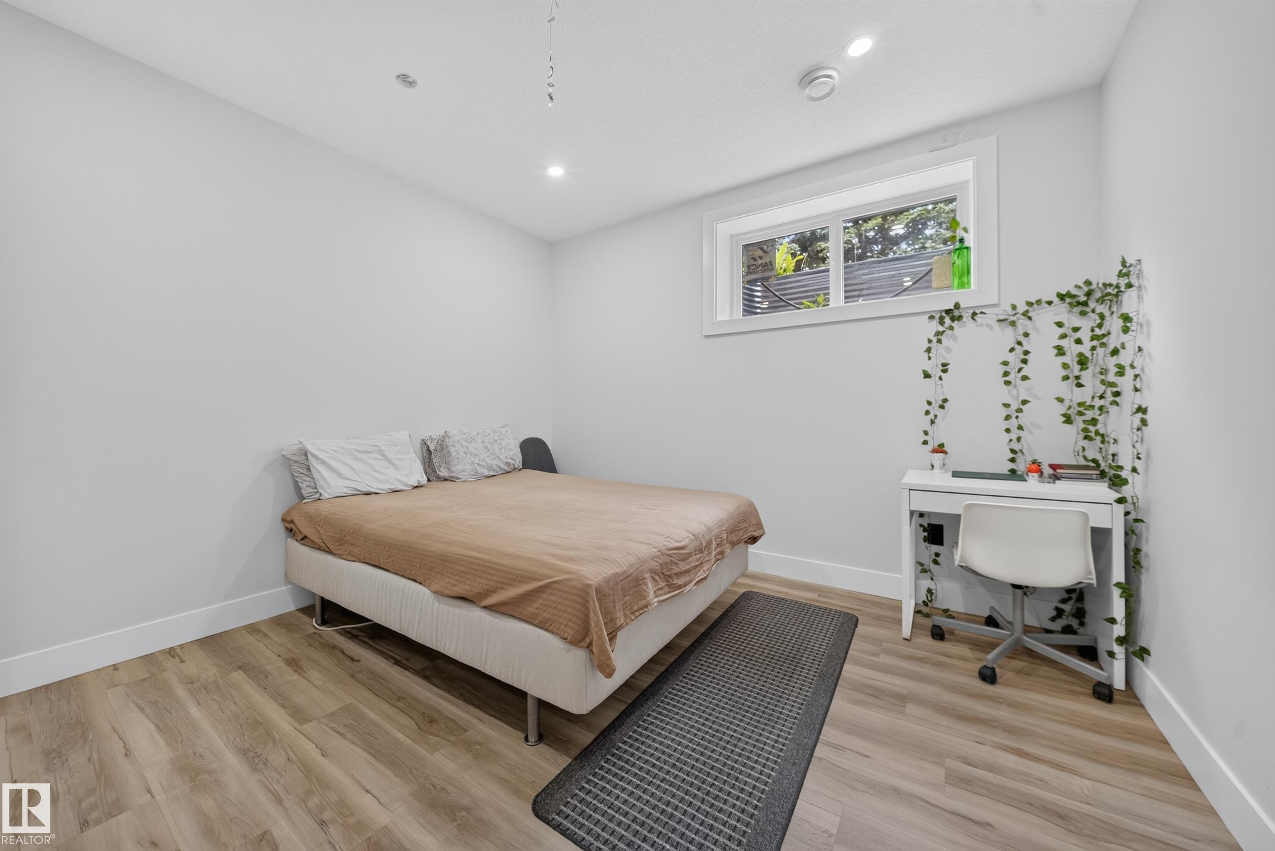 Recessed lighting, wood-finish flooring, and a window with white trim - 719 65 Ave Nw, Edmonton, AB