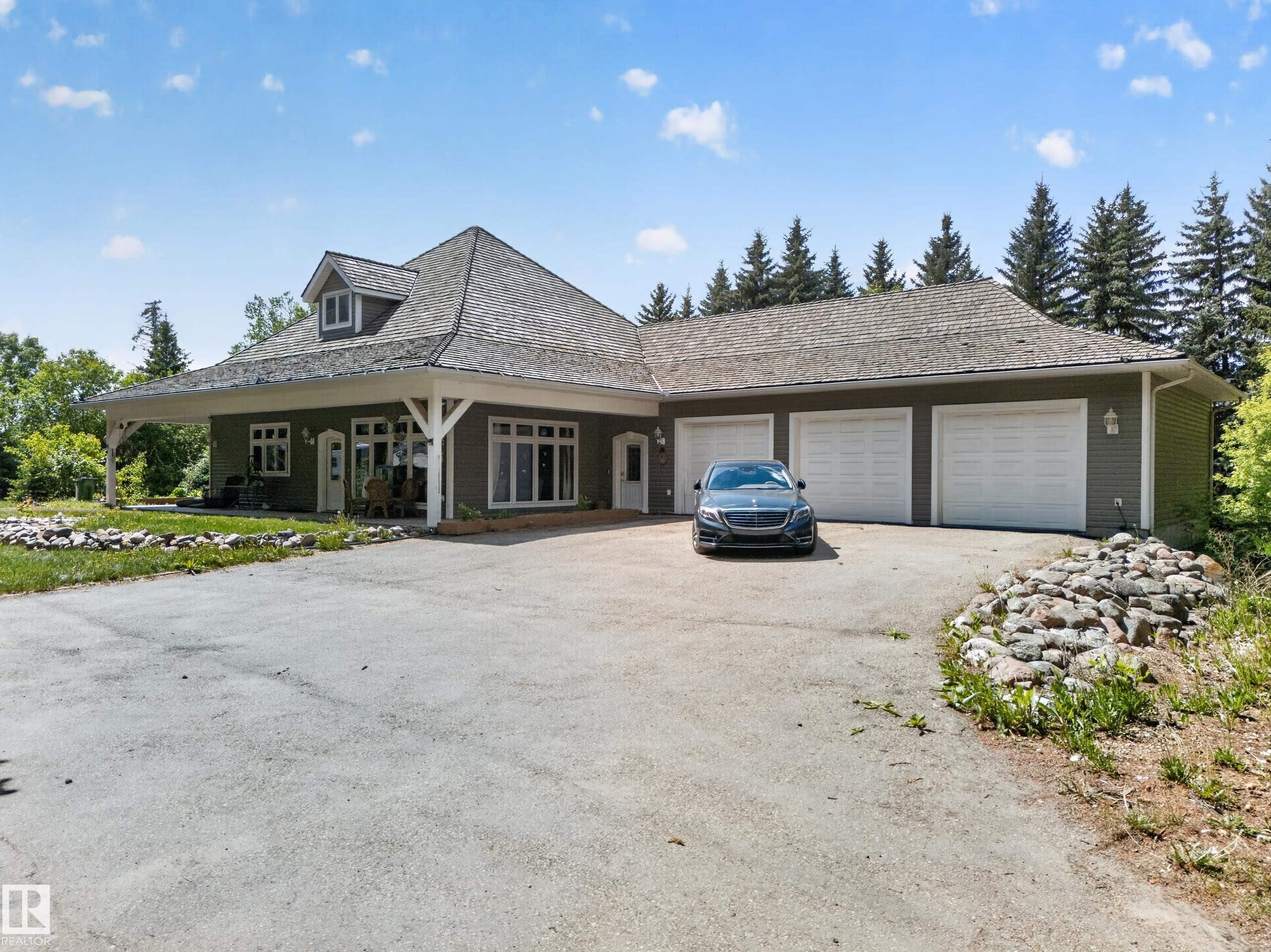 Expansive asphalt driveway leading to a three-car garage - 719 65 Ave Nw, Edmonton, AB