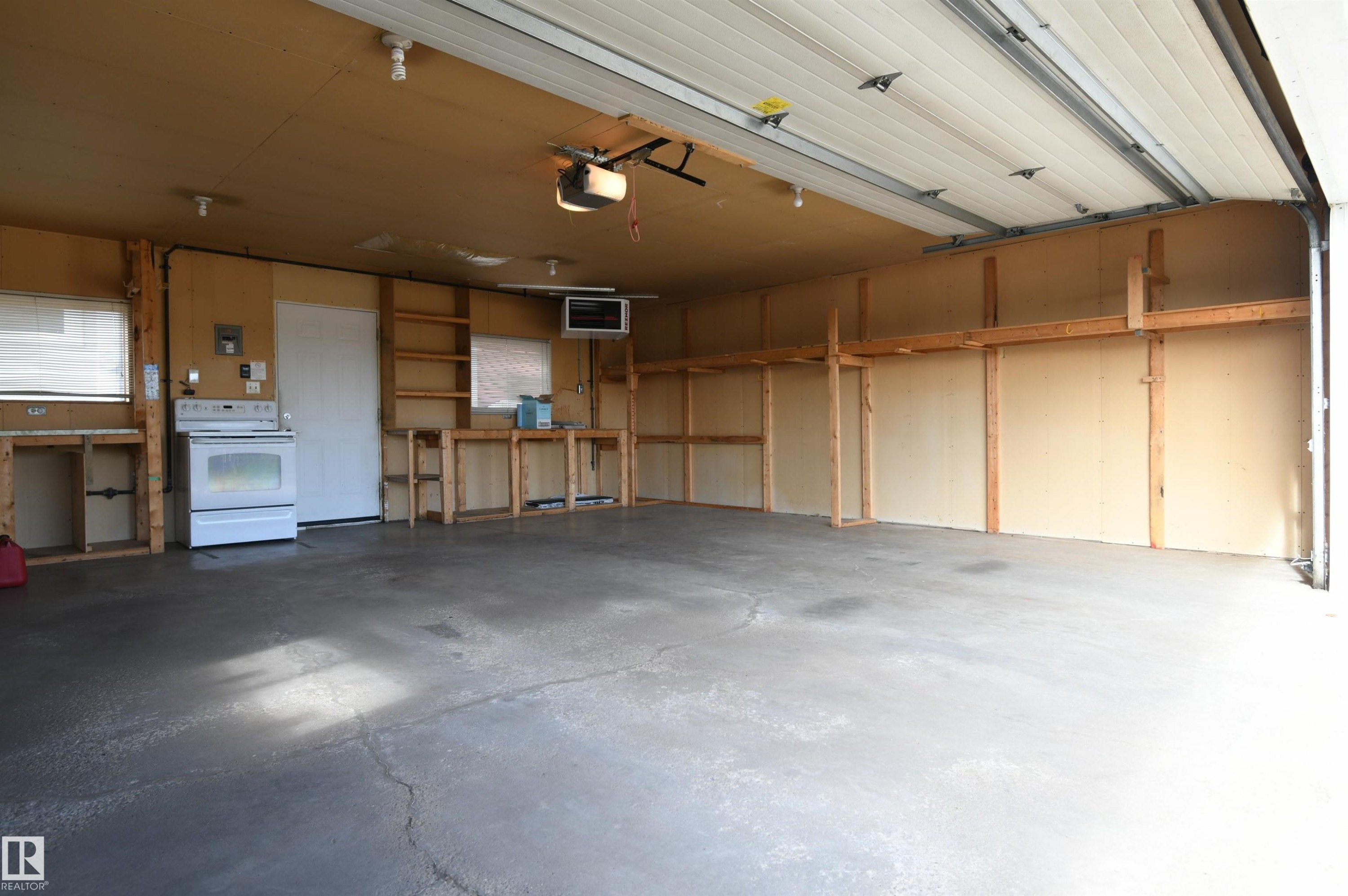 The garage is oversized, insulated, and has a new Reznor heater installed. Full driveway in front of the garage is great for additional parking or projects, and the 220V plug in the garage is perfect for anyone with hobby or tool needs, or an EV charger - 10243 42 Street Nw, Edmonton, AB