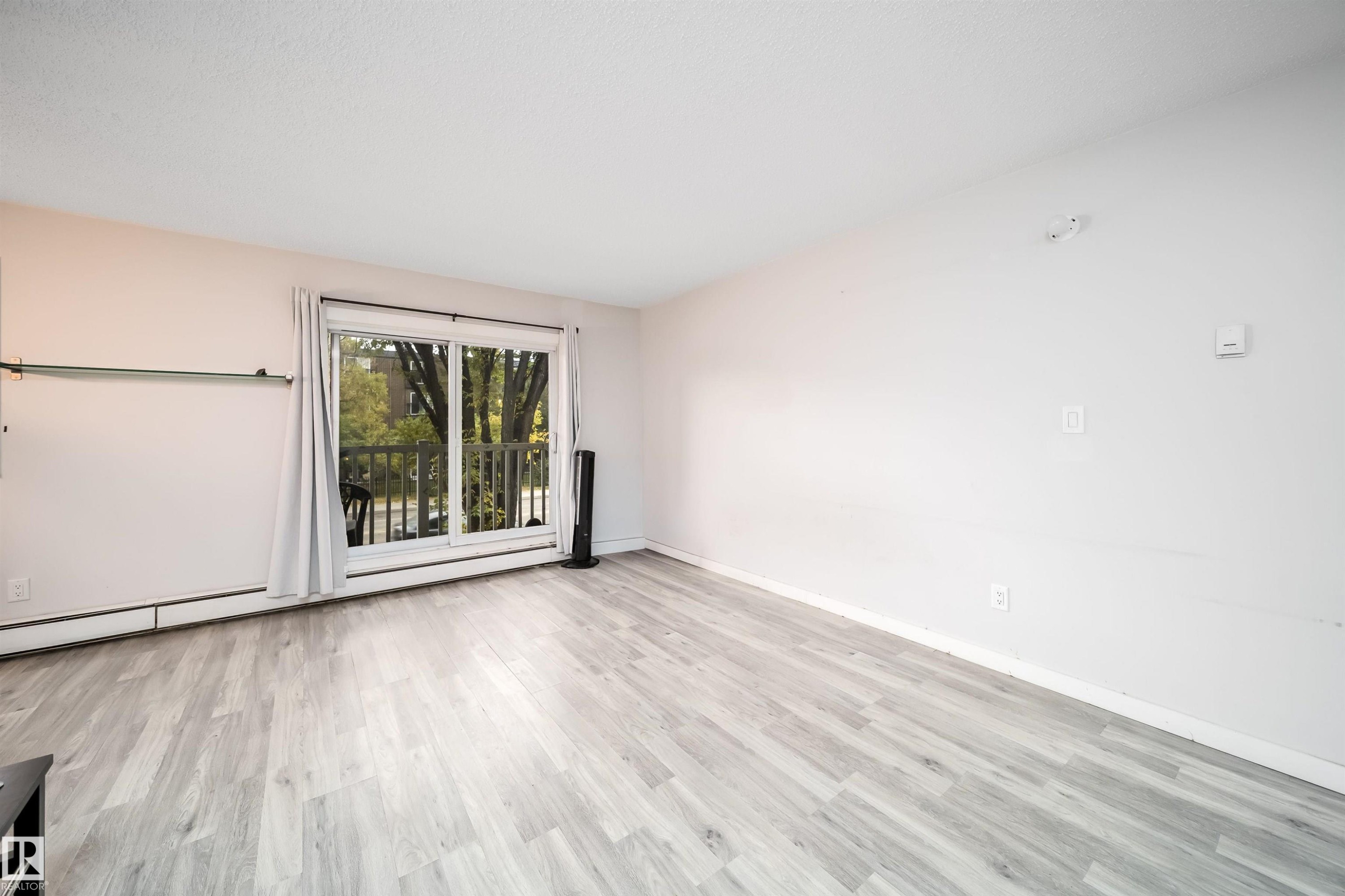 Light-toned wood-finish flooring complements the neutral wall color - #202 10615 156 St Nw, Edmonton, AB