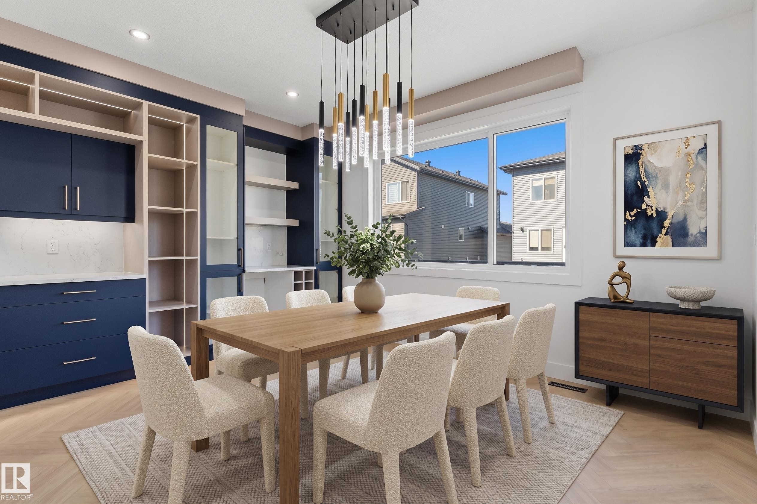 Built-in cabinetry with display shelving, a contemporary chandelier, large windows, and herringbone wood-finish flooring - 2720 63 Avenue, Rural Leduc County, AB