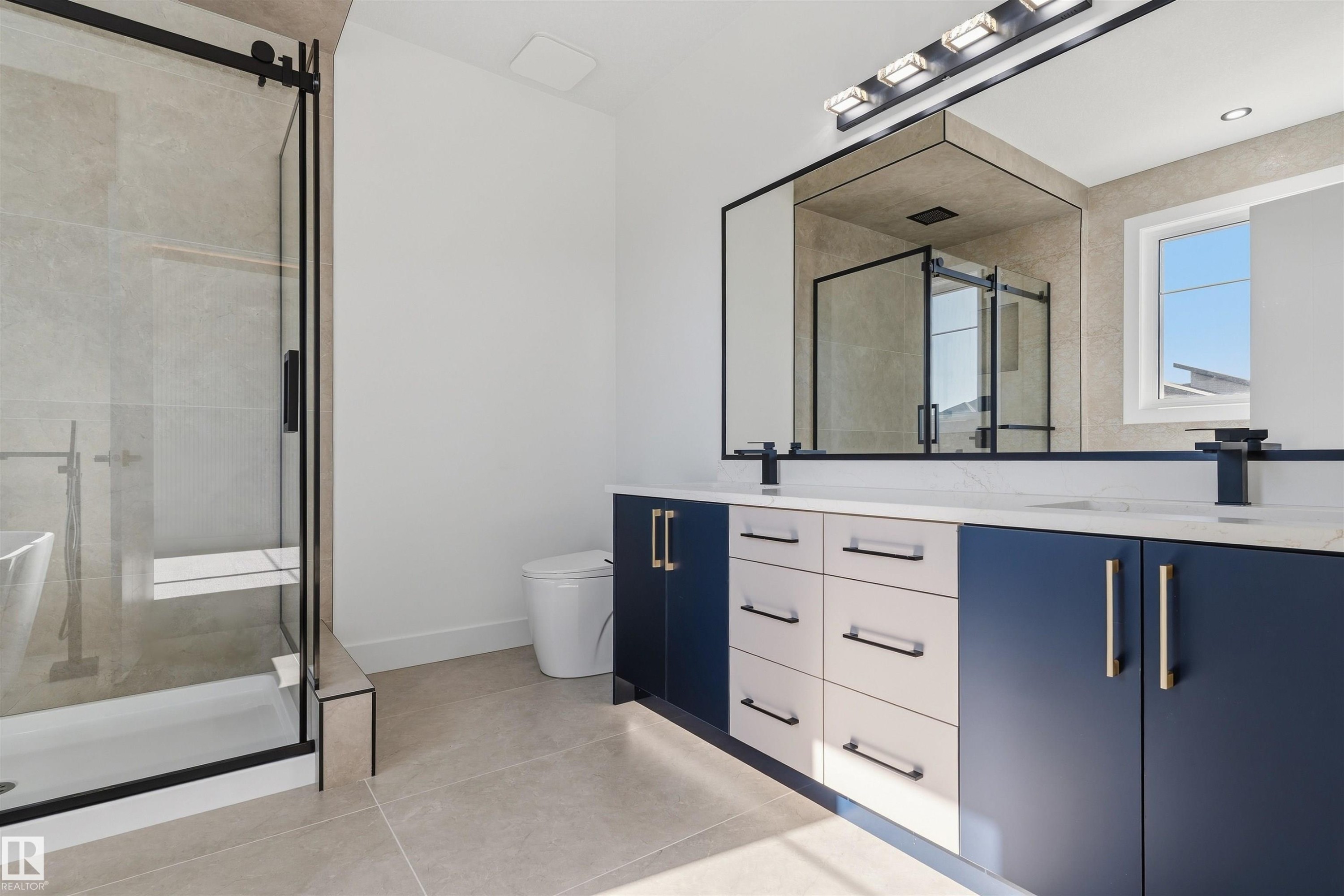 Dual vanity with a white countertop and contrasting navy and white cabinetry - 2720 63 Avenue, Rural Leduc County, AB