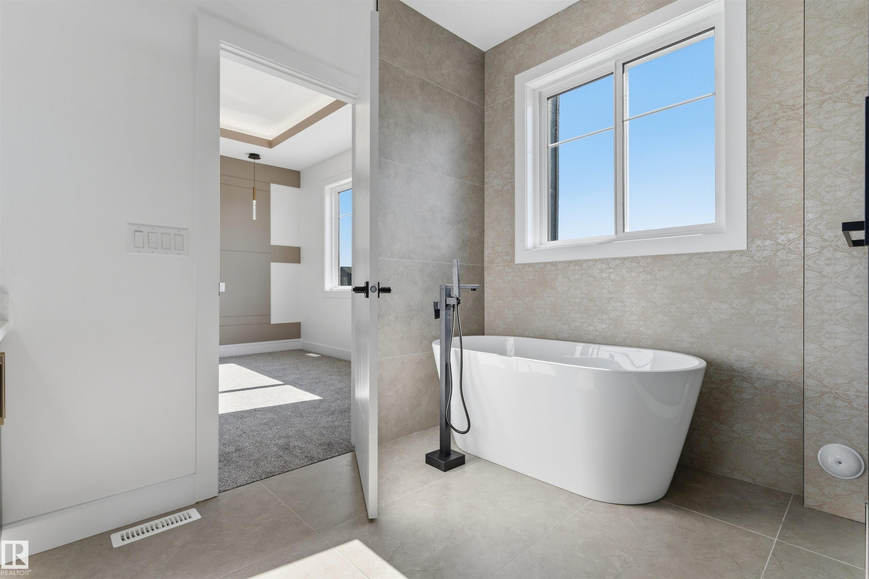 Freestanding soaking tub with a floor-mounted matte black faucet - 2720 63 Avenue, Rural Leduc County, AB