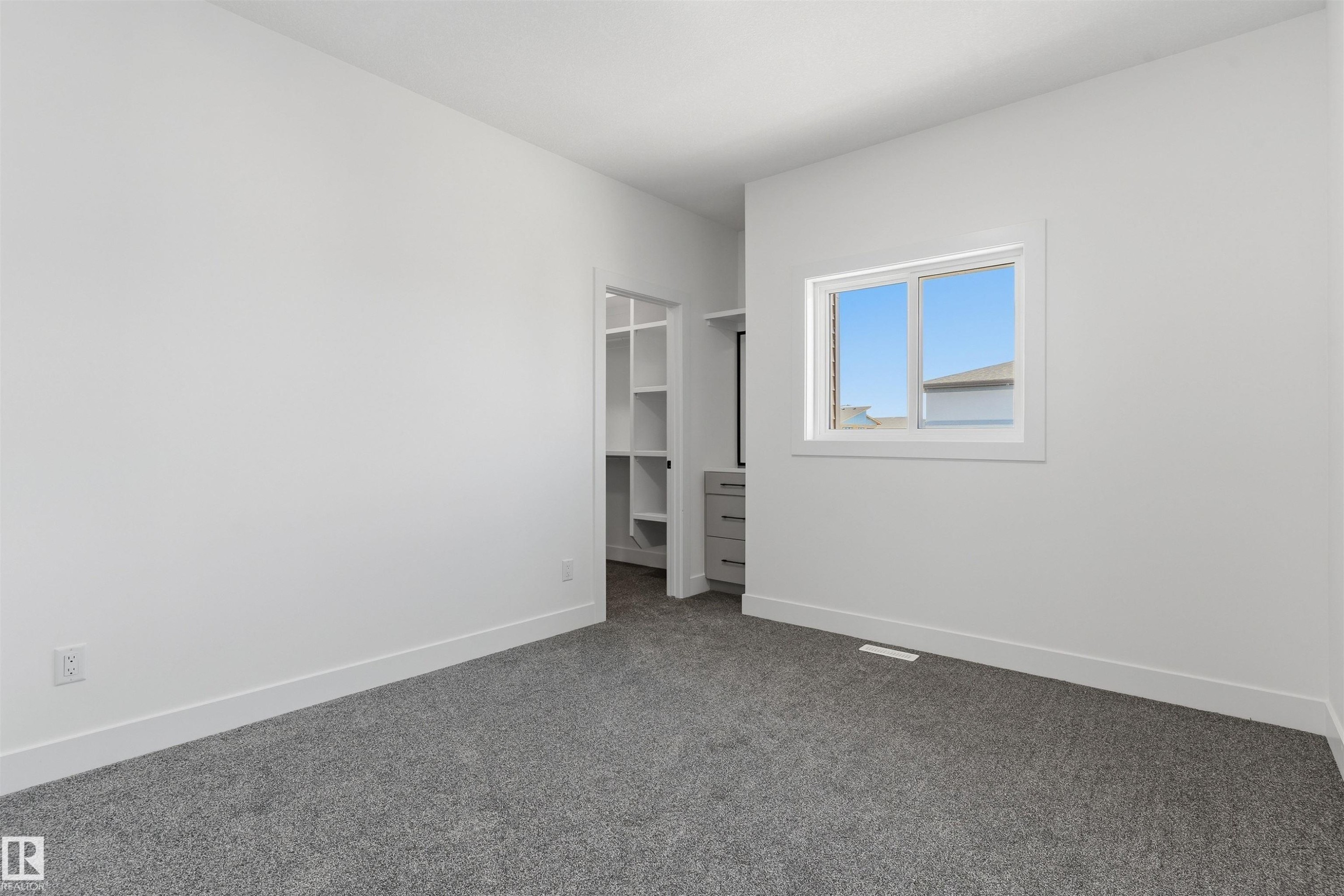 Grey carpeted flooring, white walls, and a window with white trim - 2720 63 Avenue, Rural Leduc County, AB
