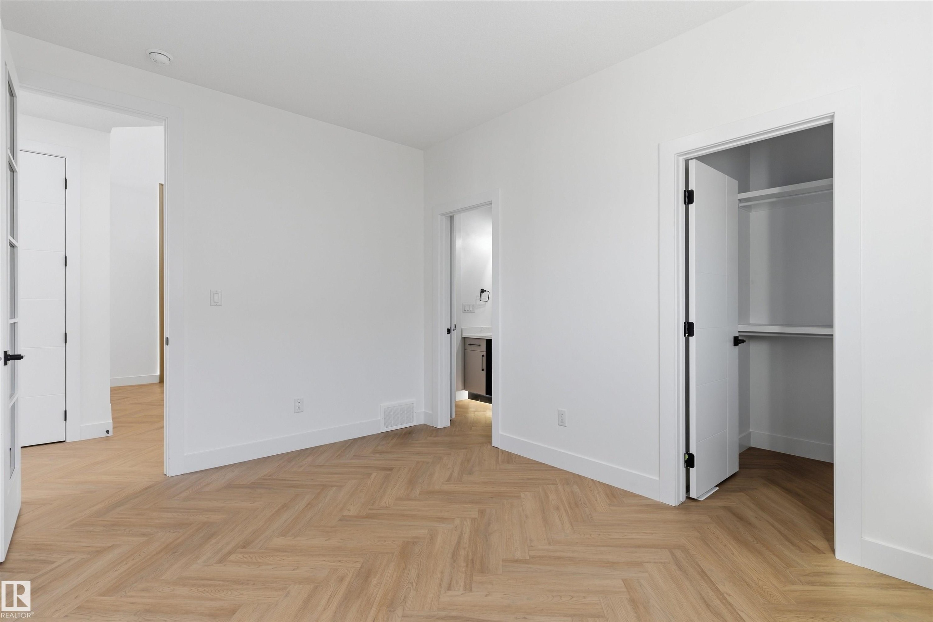 Herringbone wood-finish flooring, crisp white walls, and bright overhead lighting - 2720 63 Avenue, Rural Leduc County, AB