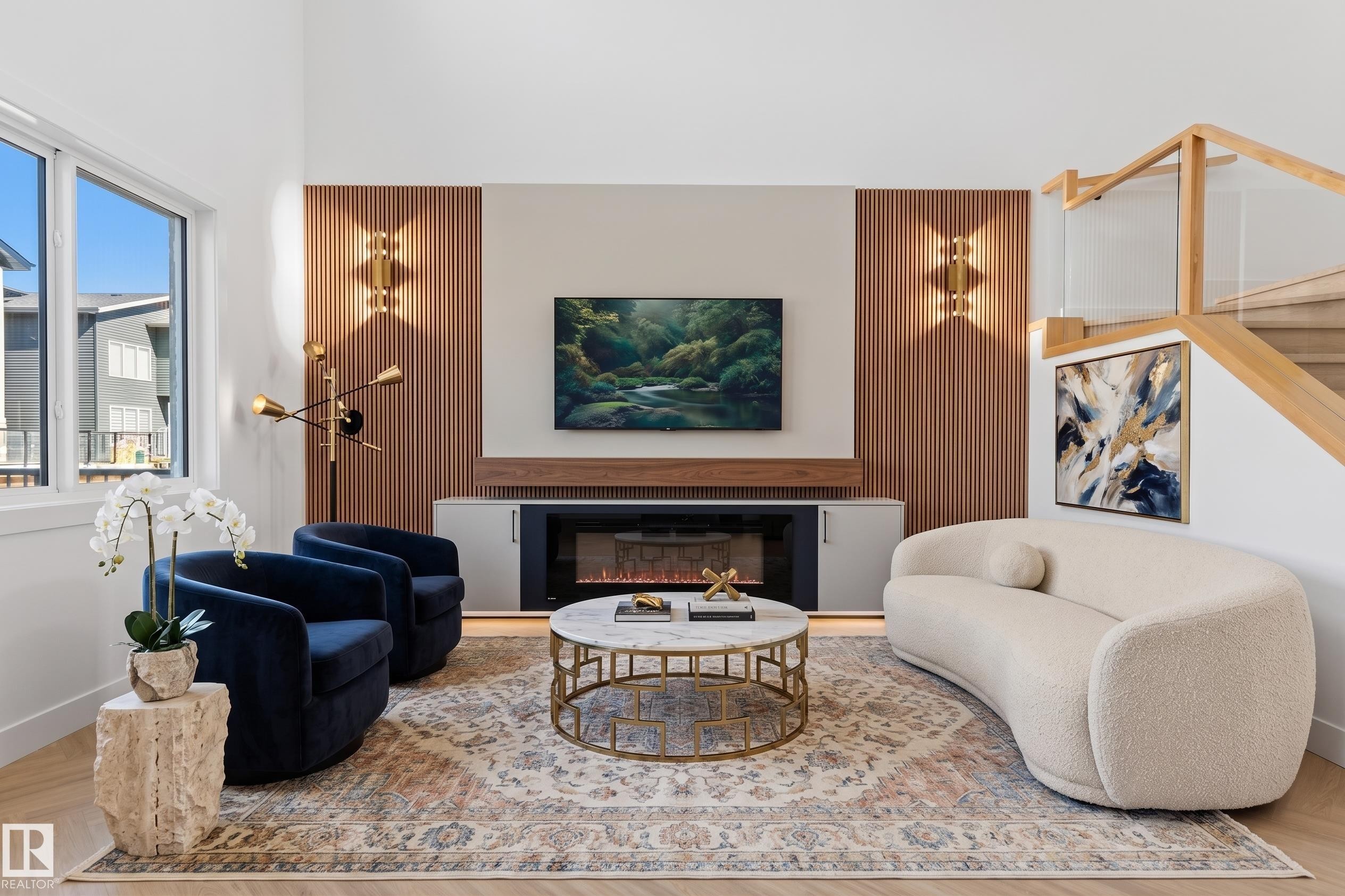 Hardwood flooring with a modern fireplace, integrated built-in cabinetry, and a wood-slat accent wall - 2720 63 Avenue, Rural Leduc County, AB