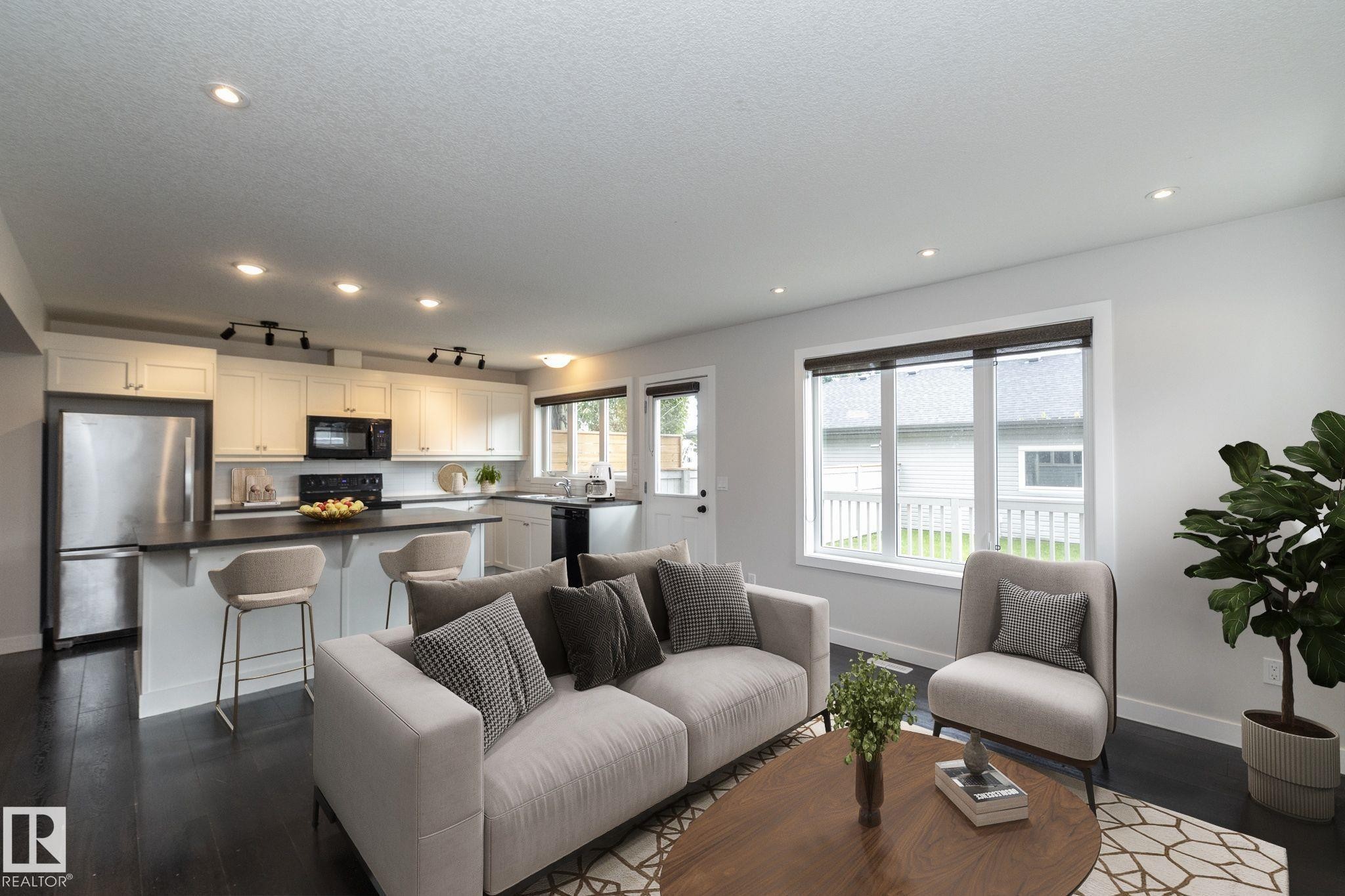 Open-concept living space with dark wood-finish flooring, recessed lighting, and white walls - 55 Michigan Street, Devon, AB