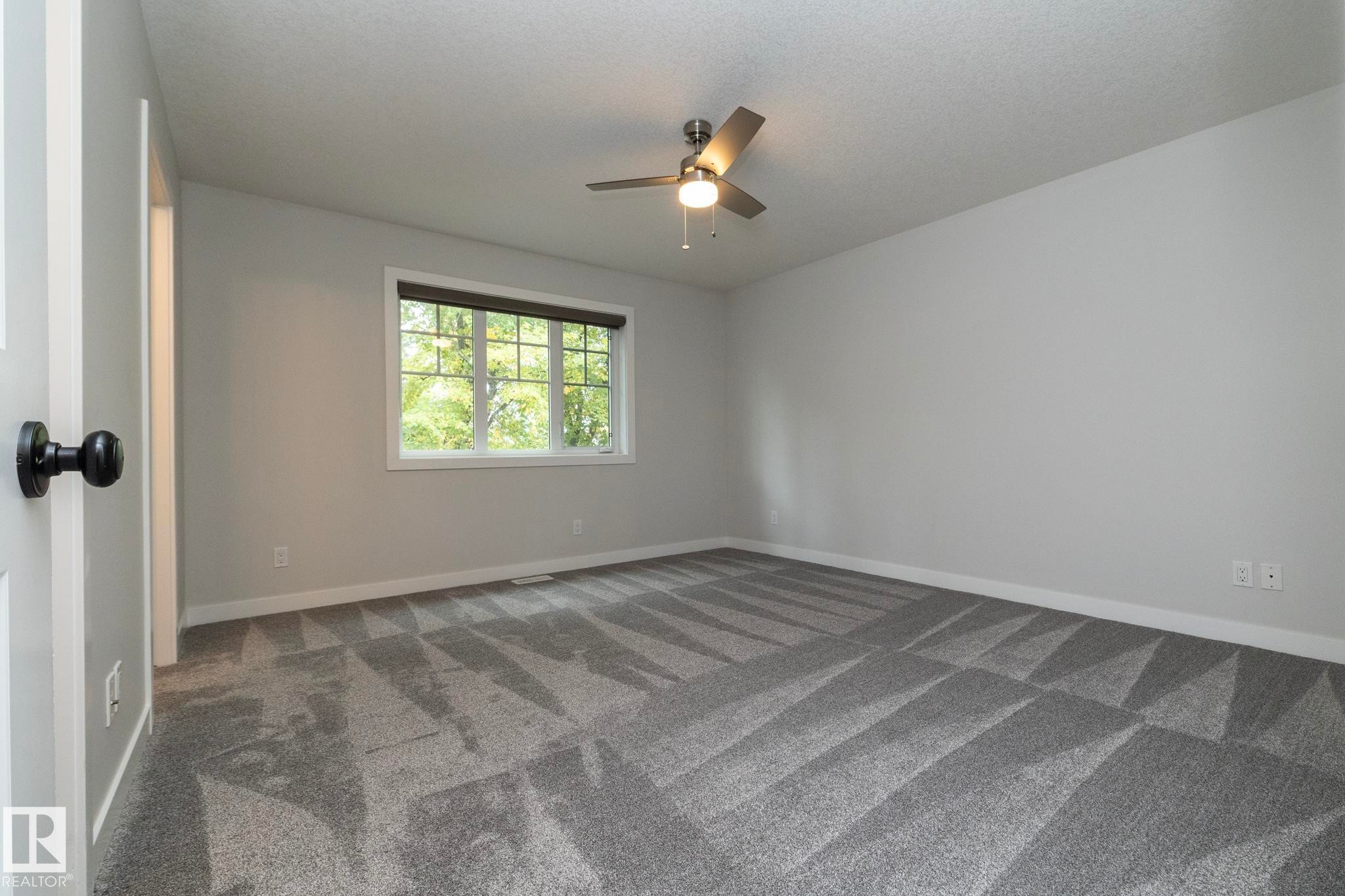 Neutral gray walls complement the patterned gray carpet - 55 Michigan Street, Devon, AB