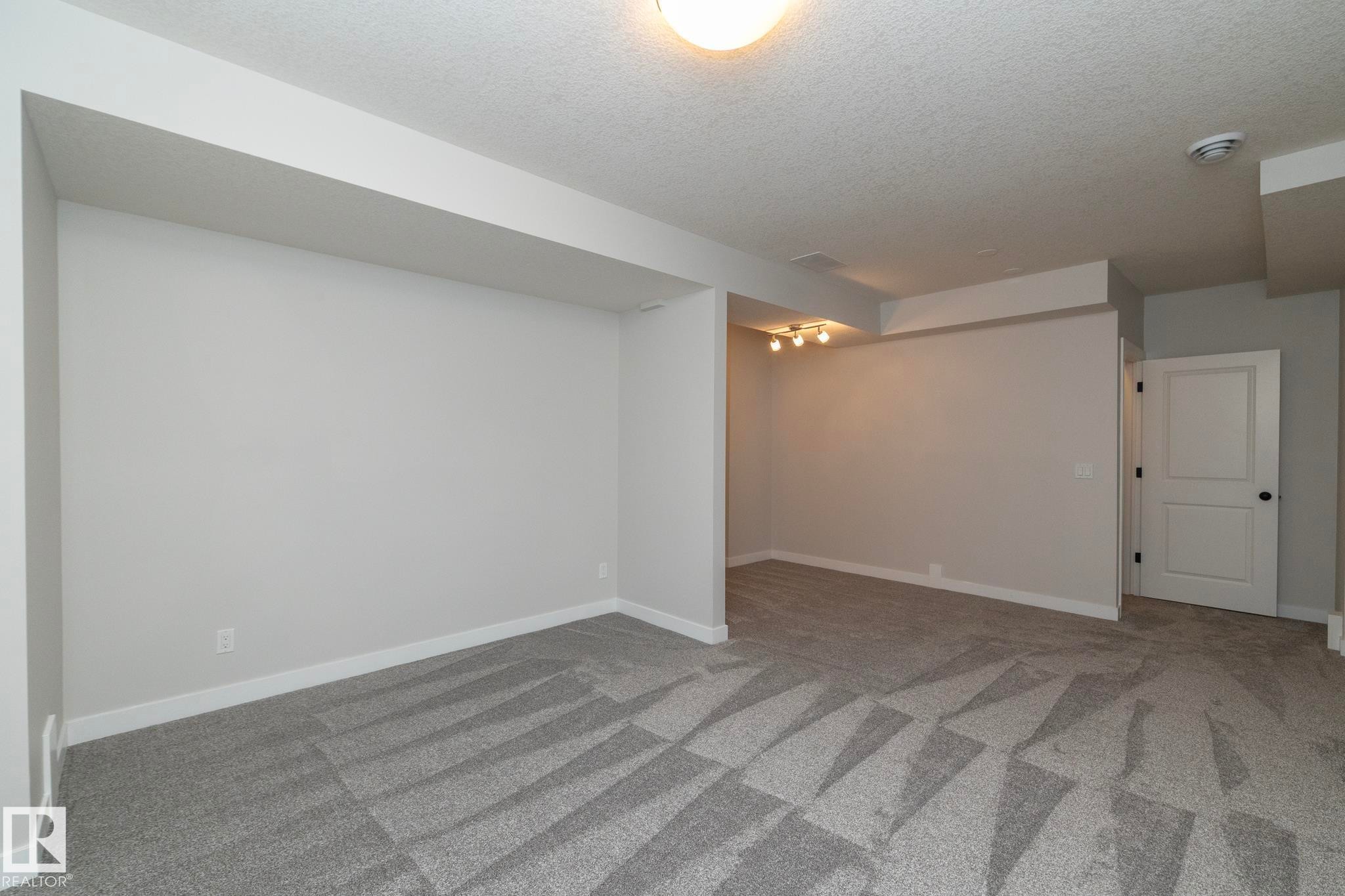 Recessed lighting, patterned carpet flooring, flush mount ceiling light, white interior door with black hardware, and neutral wall tones - 55 Michigan Street, Devon, AB