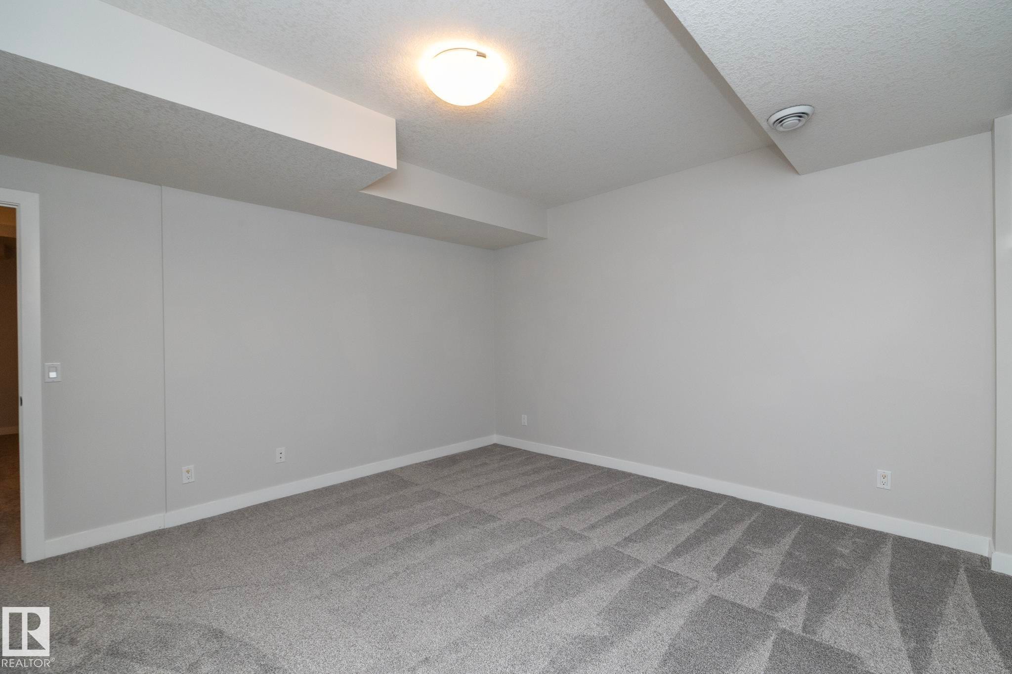 Plush gray patterned carpeting and light gray wall paint - 55 Michigan Street, Devon, AB