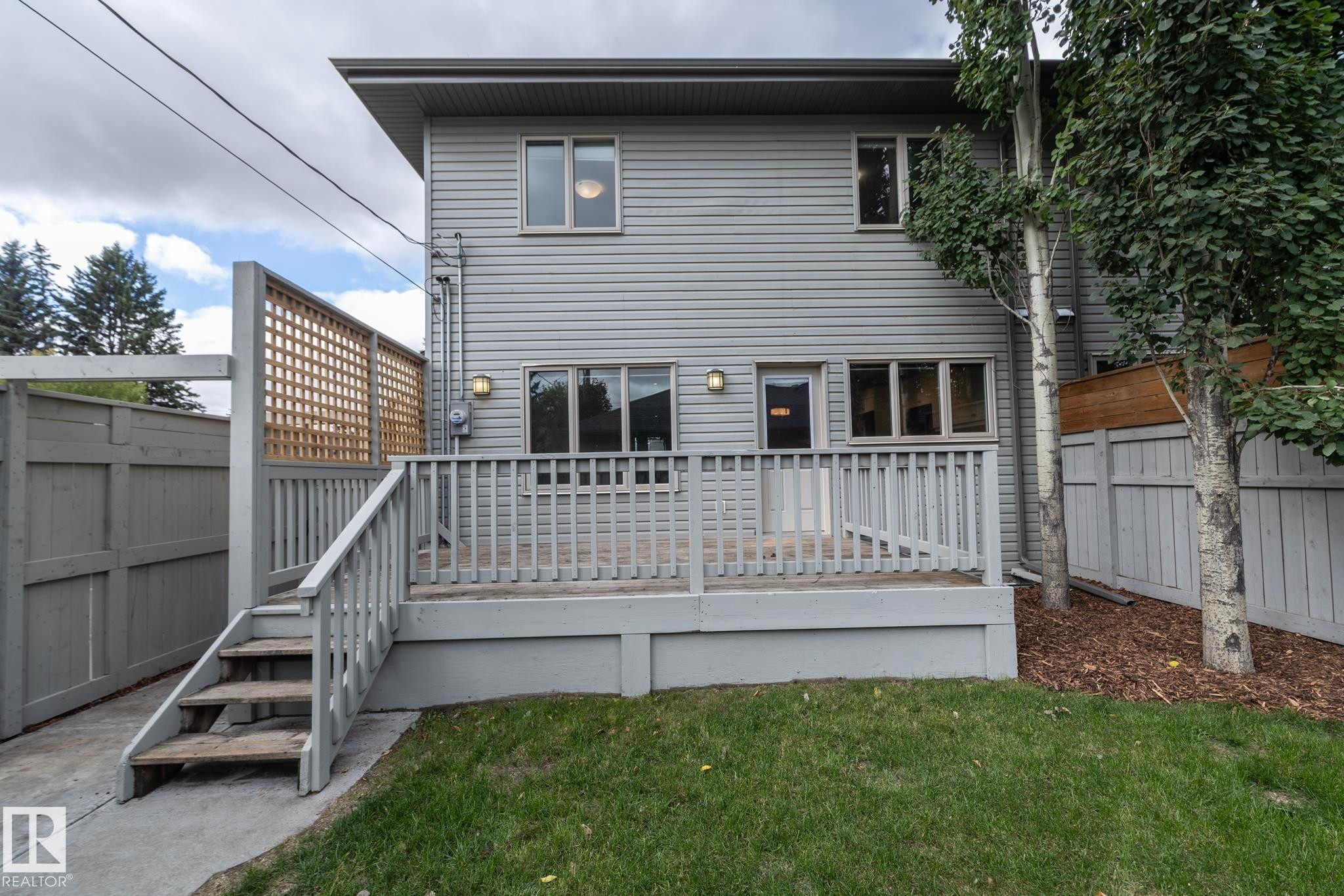 Rear exterior with a wood deck, steps, and slat privacy screen - 55 Michigan Street, Devon, AB