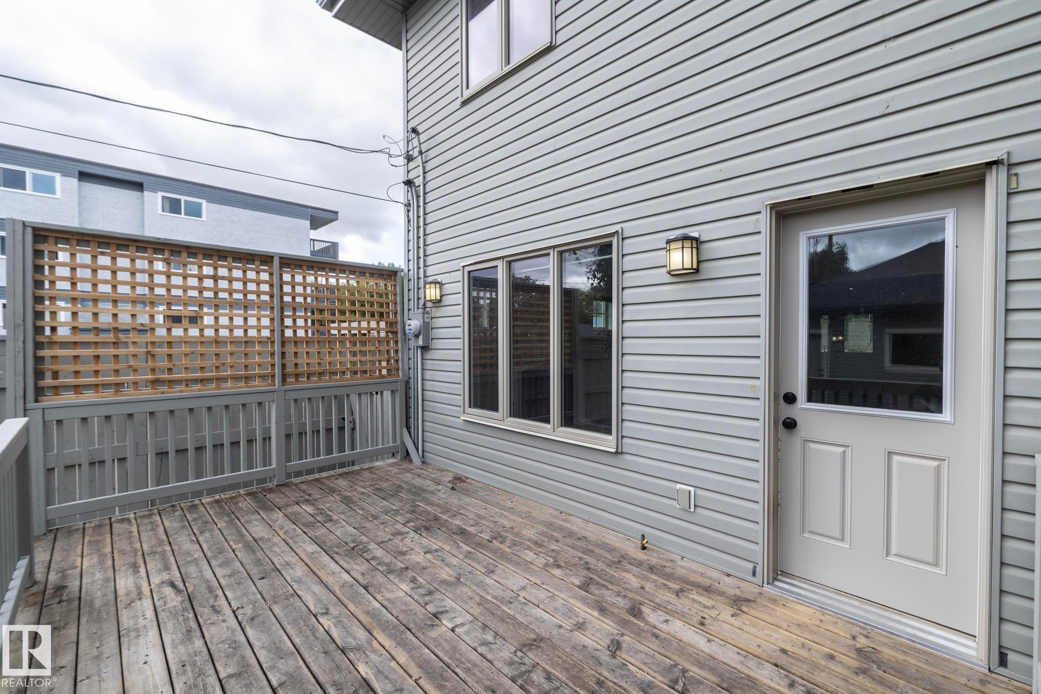 Expansive wooden deck with coordinating wooden railing and privacy lattice - 55 Michigan Street, Devon, AB
