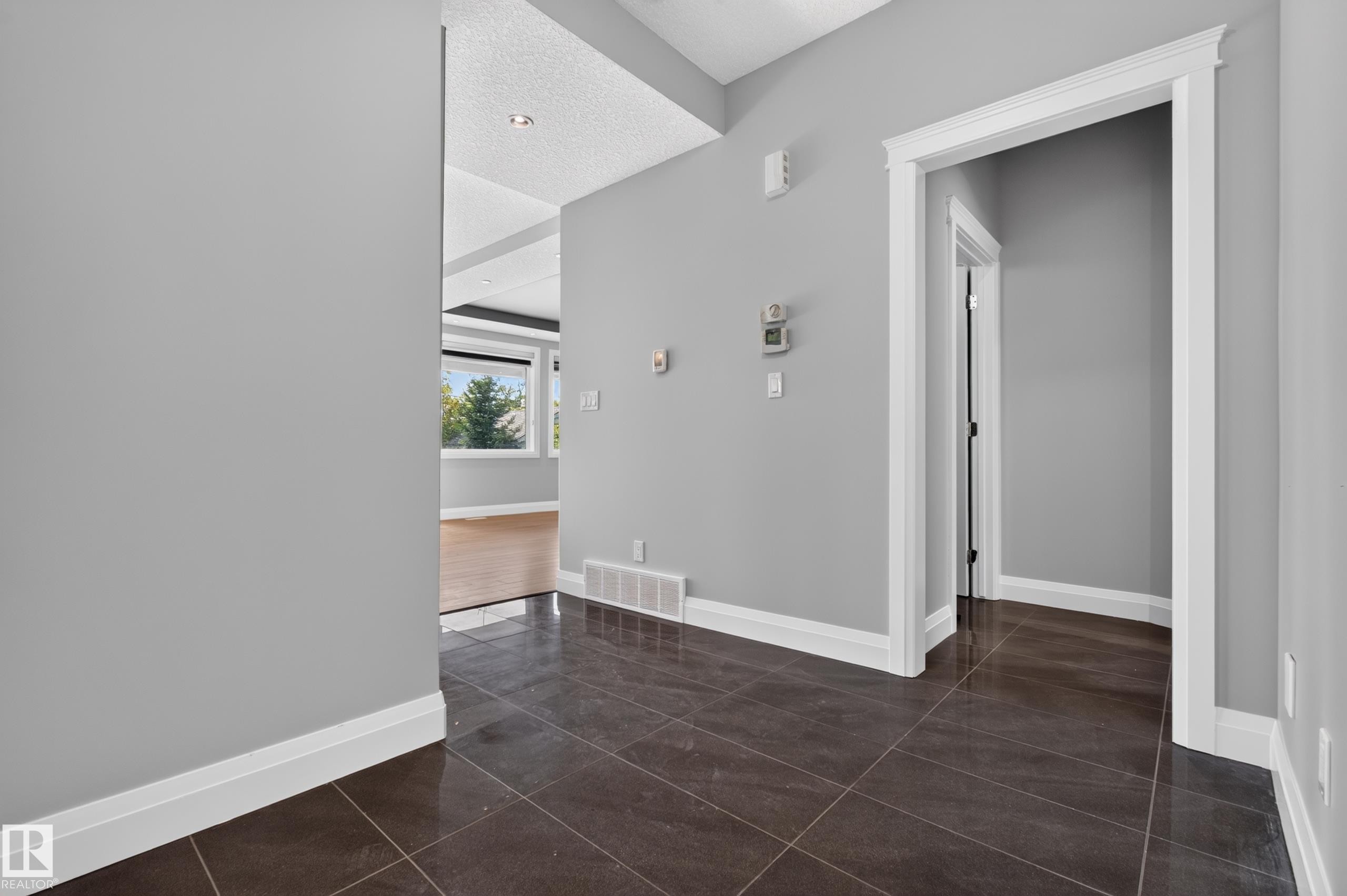 Dark tile flooring, light gray wall paint, white trim, recessed ceiling lighting, and a window with outdoor scenery - 11167 62 Avenue Nw, Edmonton, AB