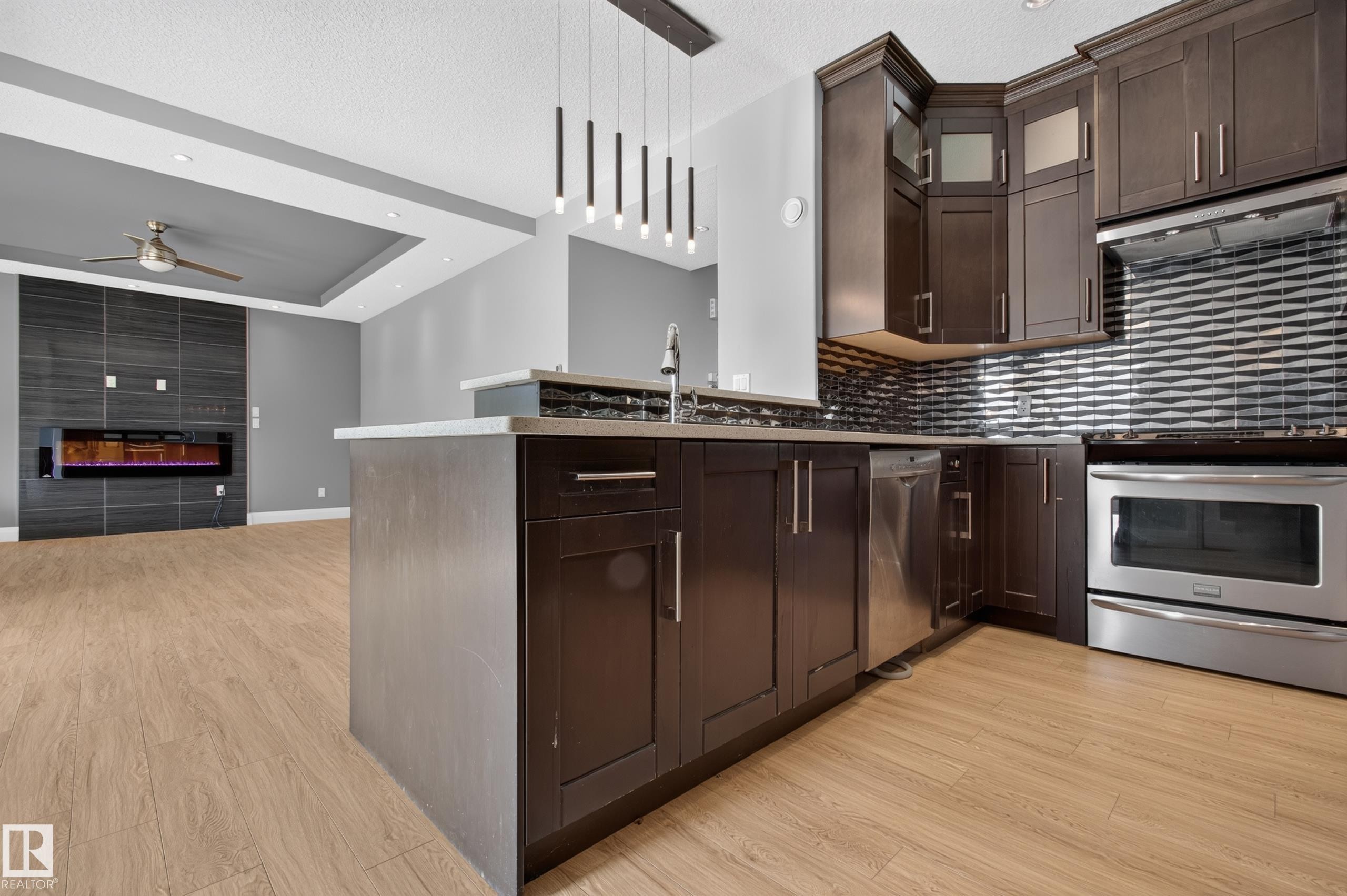Kitchen with dark wood cabinetry, stainless steel appliances, and a tiled backsplash - 11167 62 Avenue Nw, Edmonton, AB