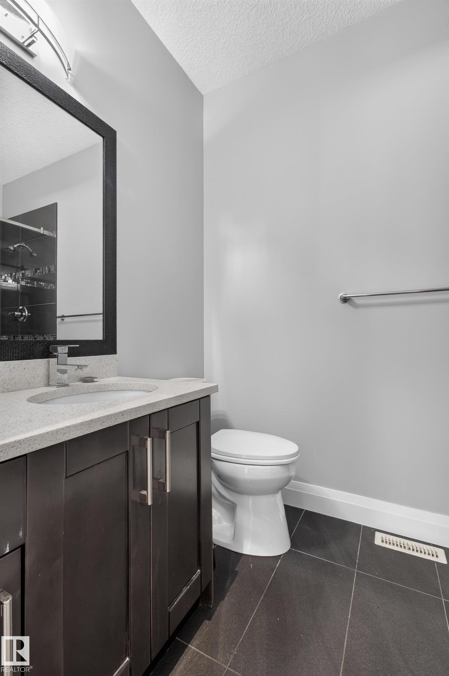 Dark wood-finish vanity with chrome hardware, an integrated sink, and a light-toned countertop - 11167 62 Avenue Nw, Edmonton, AB