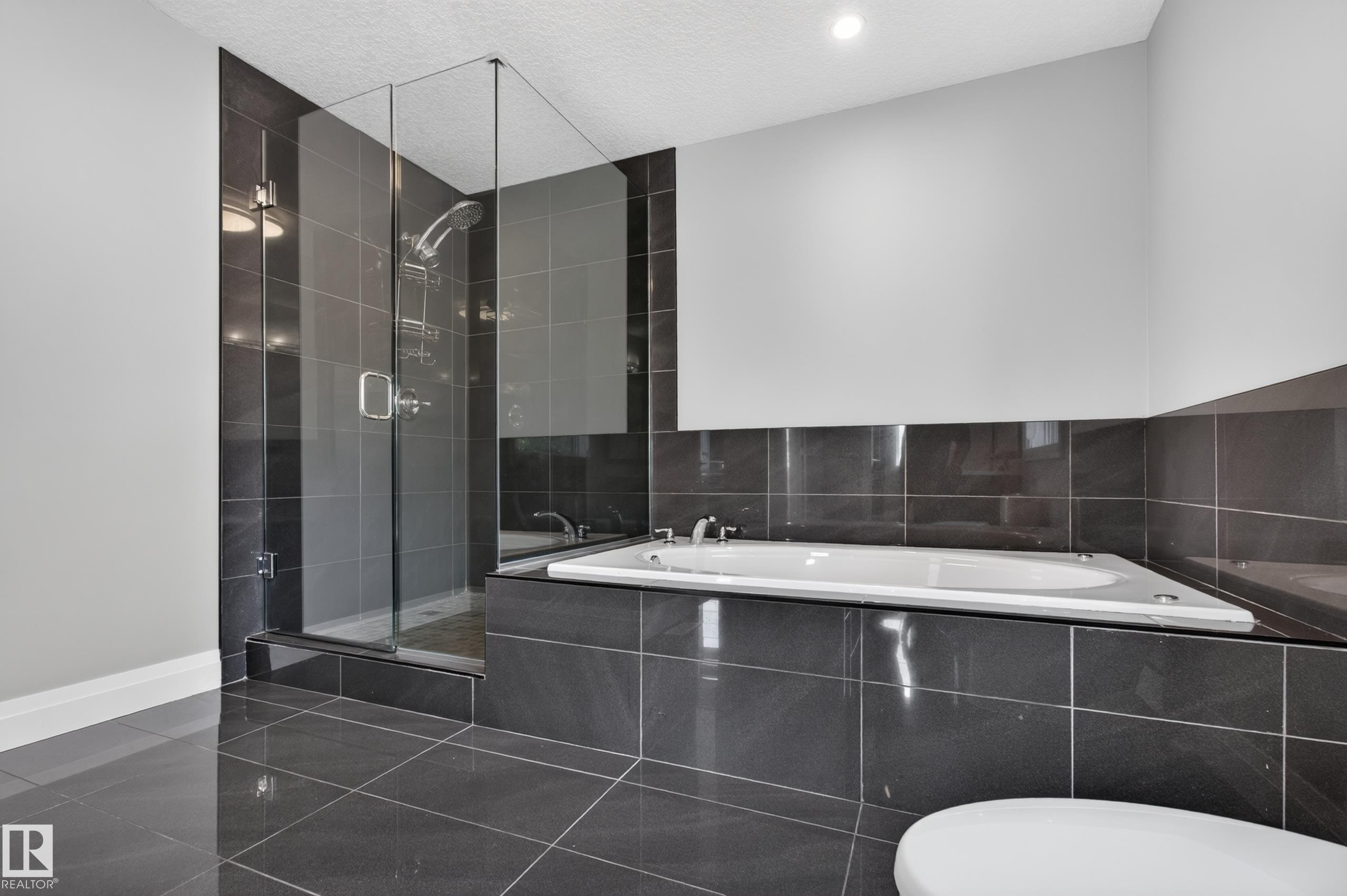 Glass-enclosed shower with a rainfall showerhead, and a built-in tub with tile surround - 11167 62 Avenue Nw, Edmonton, AB