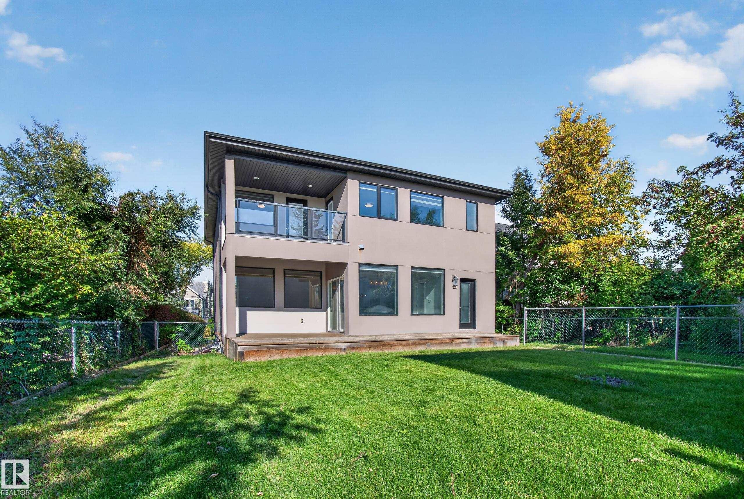 Modern two-story exterior with a neutral-toned facade, black-framed windows, and a glass-paneled balcony - 11167 62 Avenue Nw, Edmonton, AB