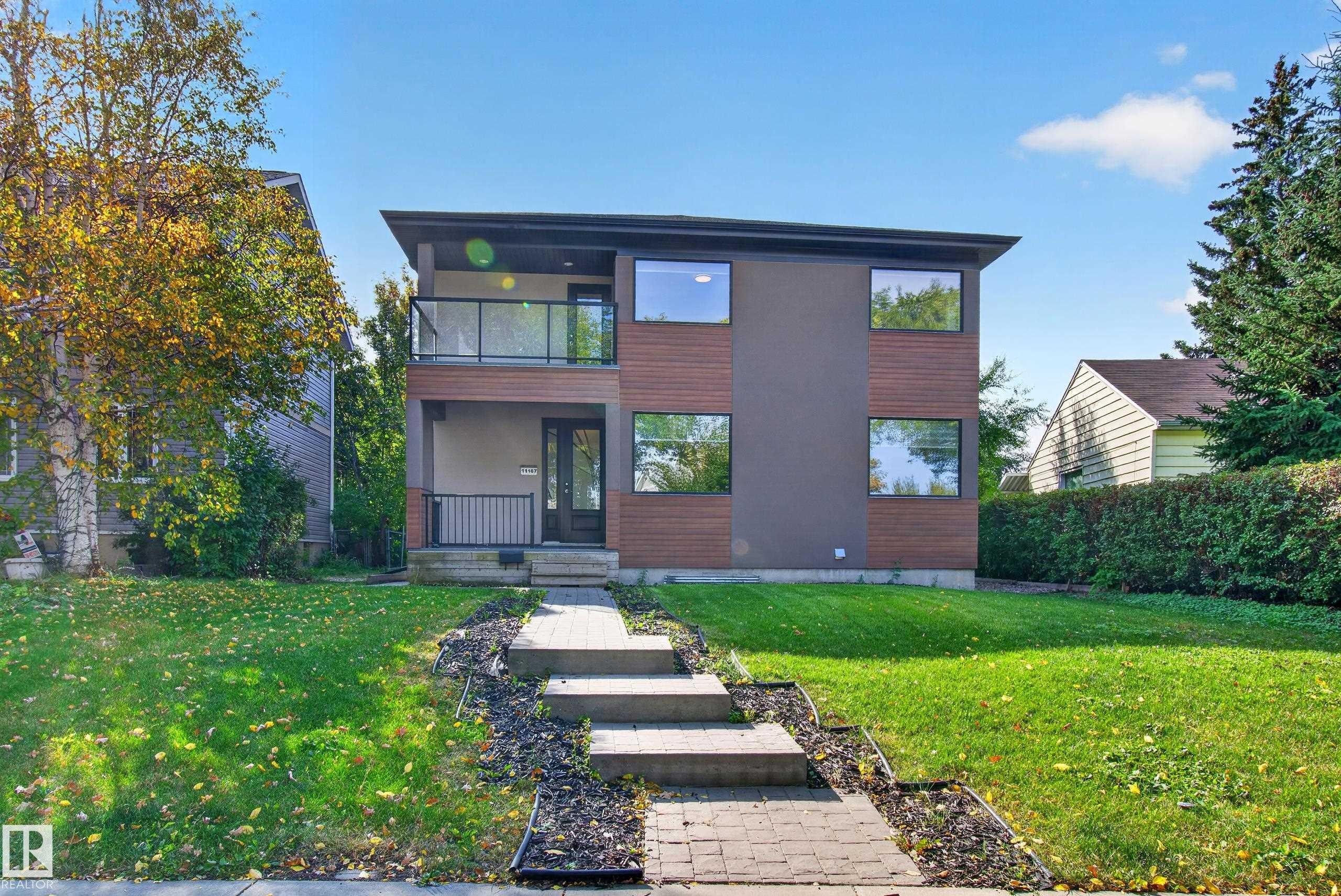 Modern architectural design with a flat roofline, multi-pane windows, and a glass balcony railing - 11167 62 Avenue Nw, Edmonton, AB
