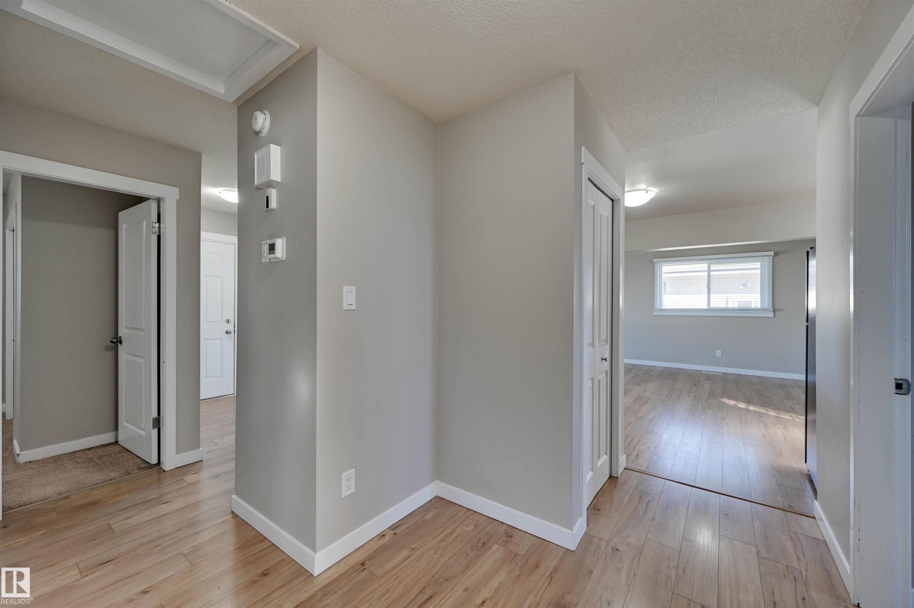 Wood-finish flooring throughout, neutral wall tones, and white trim - 13815 88 Street Nw, Edmonton, AB