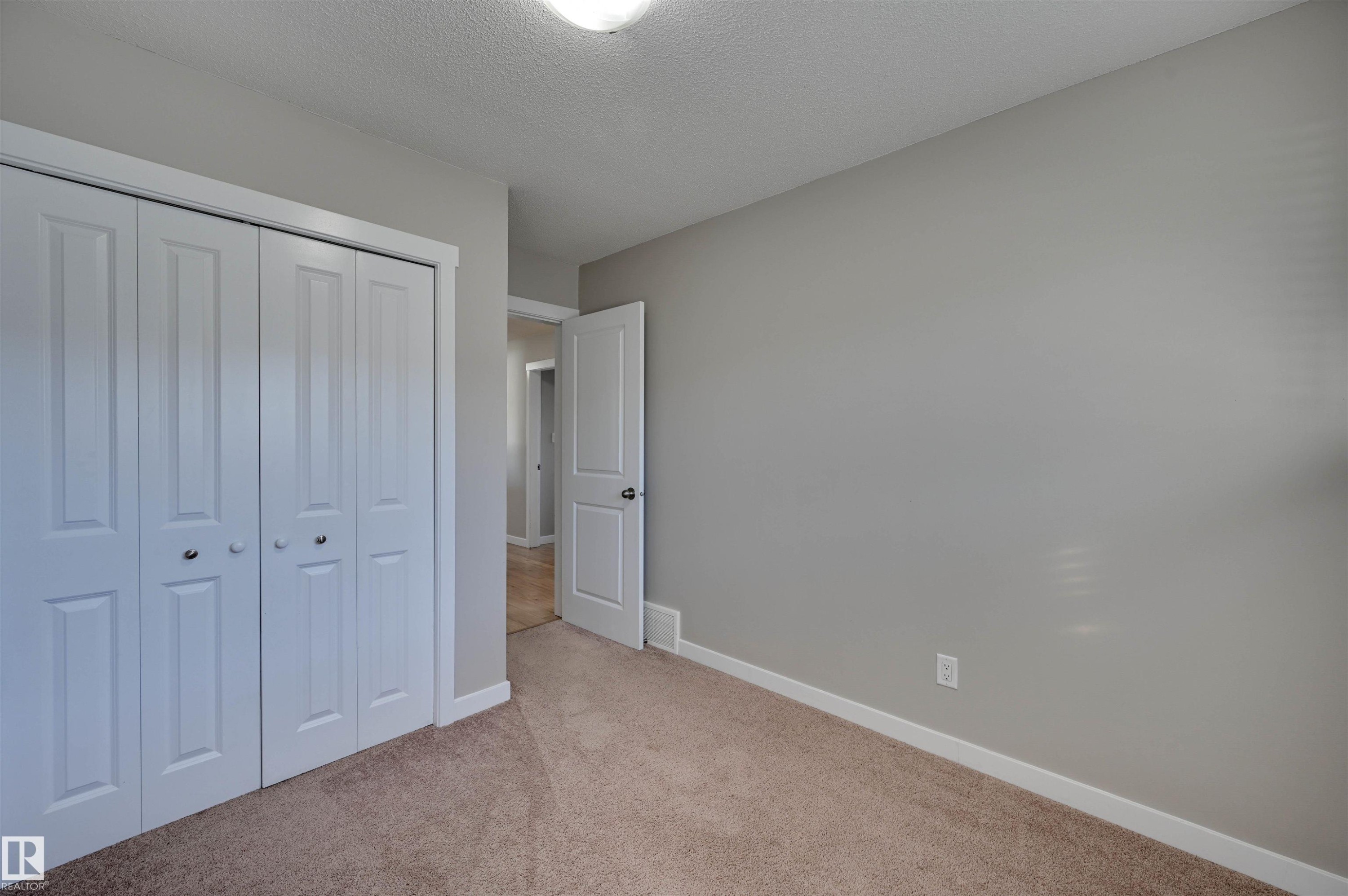 Neutral-toned walls, plush carpeting, and white trim - 13815 88 Street Nw, Edmonton, AB