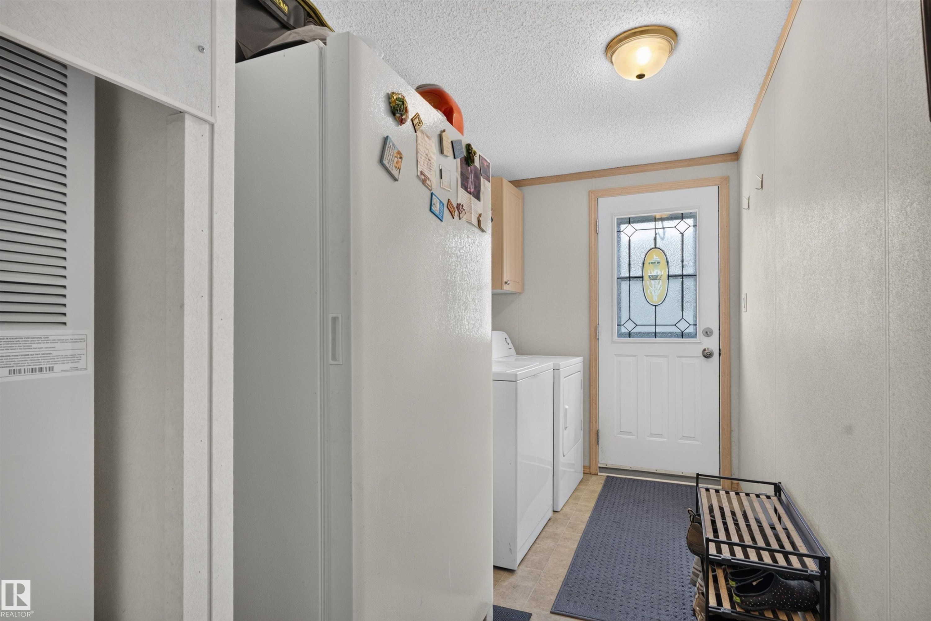 Entryway with wood-finish flooring, white paneled walls, and a white exterior door with decorative glass inlay - 1405 53222 Range Road 272, Rural Parkland County, AB
