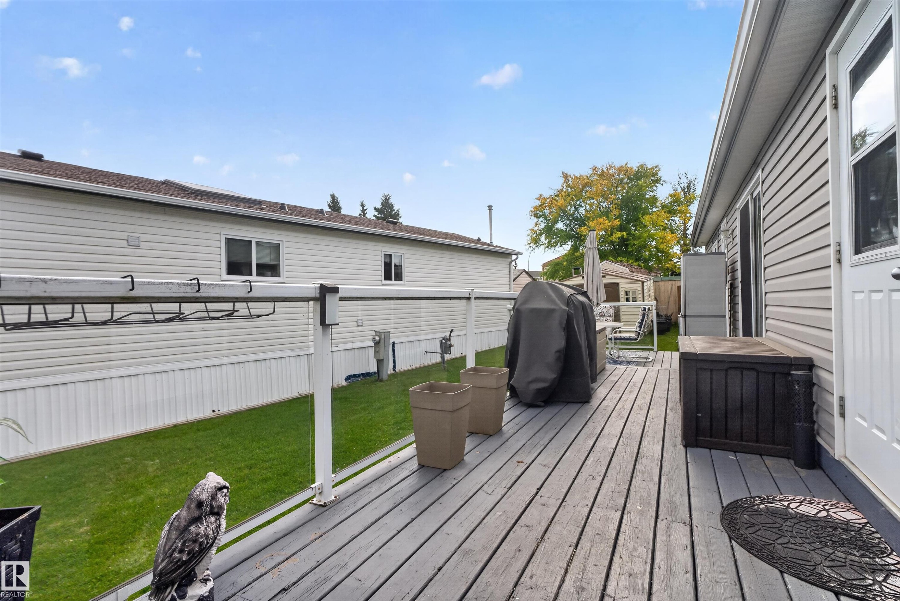 Wood-finish deck with white railings and an exterior door with a window panel - 1405 53222 Range Road 272, Rural Parkland County, AB