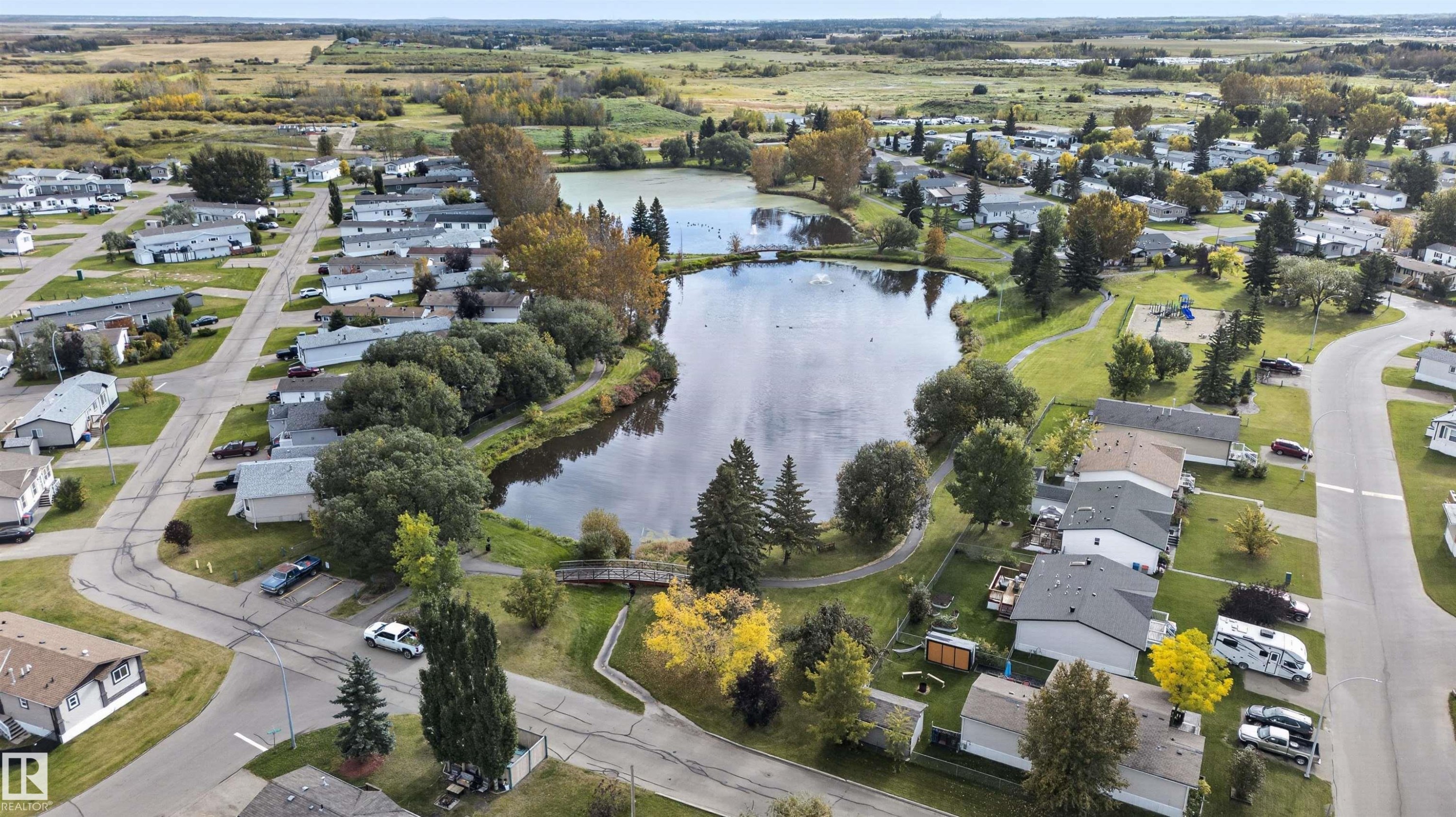 Lakeside community featuring residential properties, mature trees, and paved roads - 1405 53222 Range Road 272, Rural Parkland County, AB