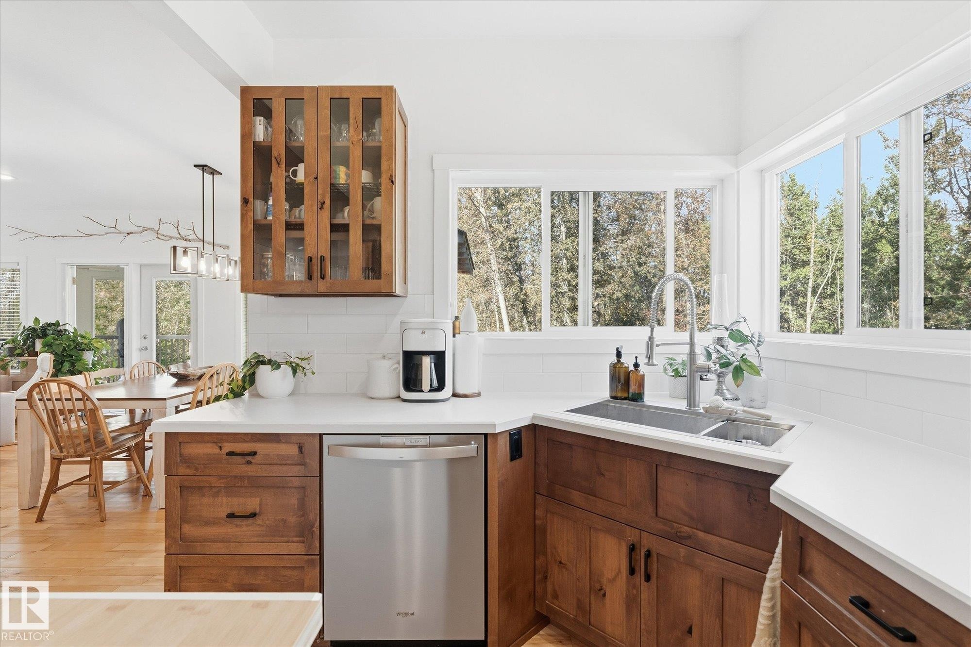 Kitchen featuring wood cabinetry, white countertops, stainless steel dishwasher, undermount sink with a gooseneck faucet, and a subway tile backsplash - #45 53122 Rge Road 14, Rural Parkland County, AB