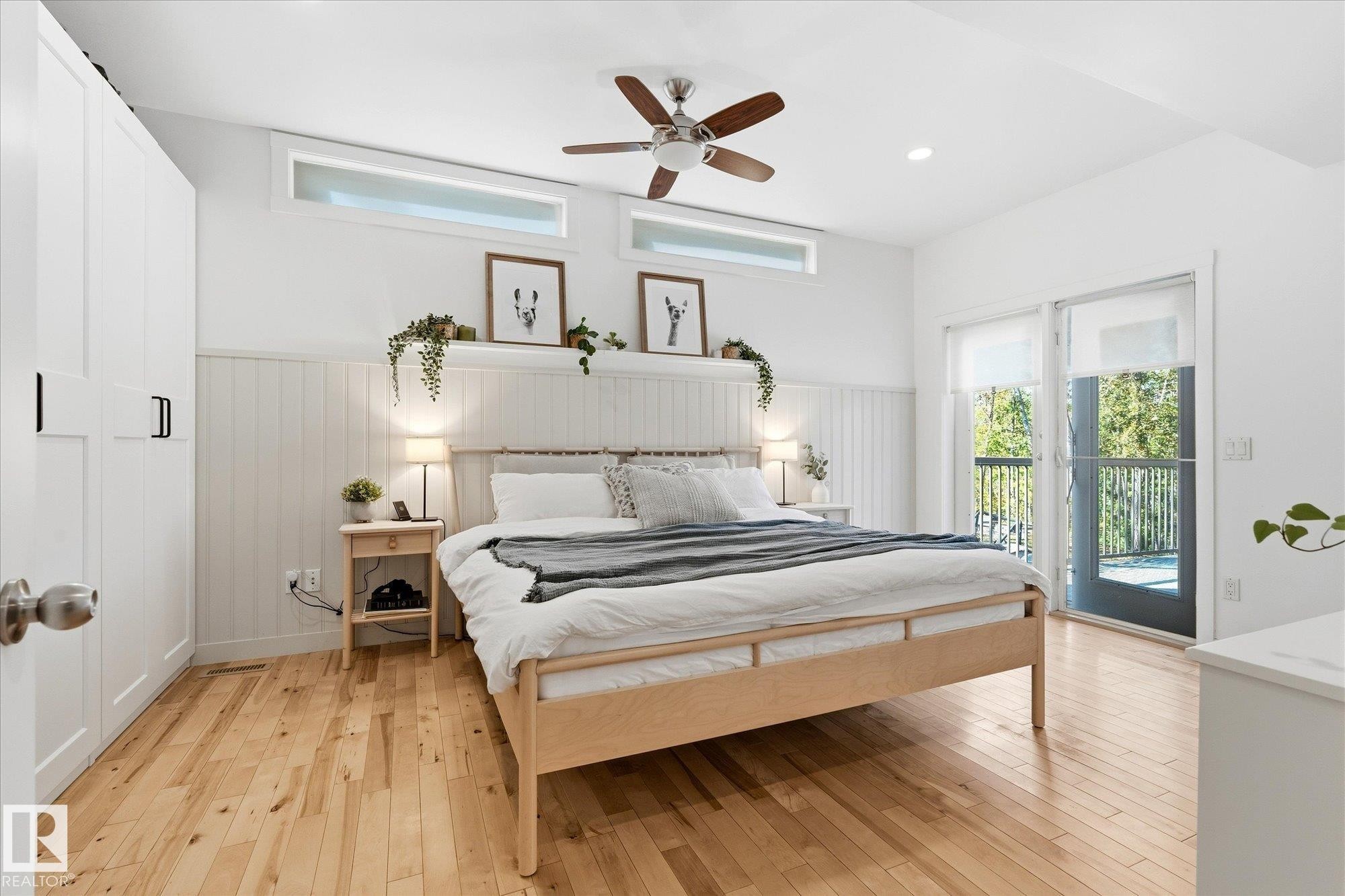 Hardwood flooring, white paneled wall accents, ceiling fan, transom windows, and sliding glass door to exterior - #45 53122 Rge Road 14, Rural Parkland County, AB