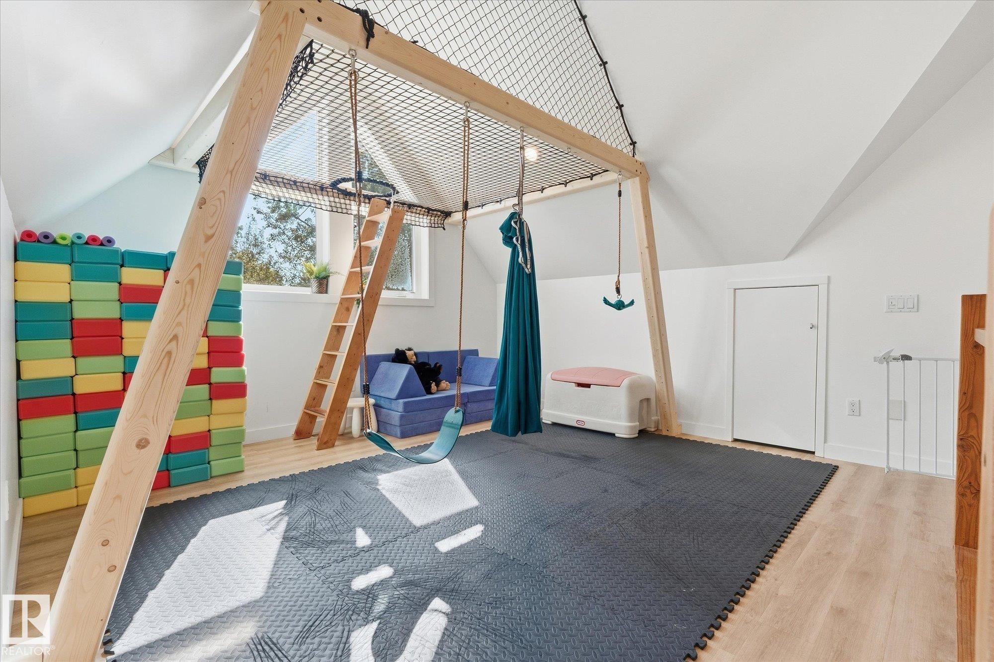 Vaulted ceiling, wood-finish flooring, built-in wooden play structure, window with exterior view, white interior door - #45 53122 Rge Road 14, Rural Parkland County, AB