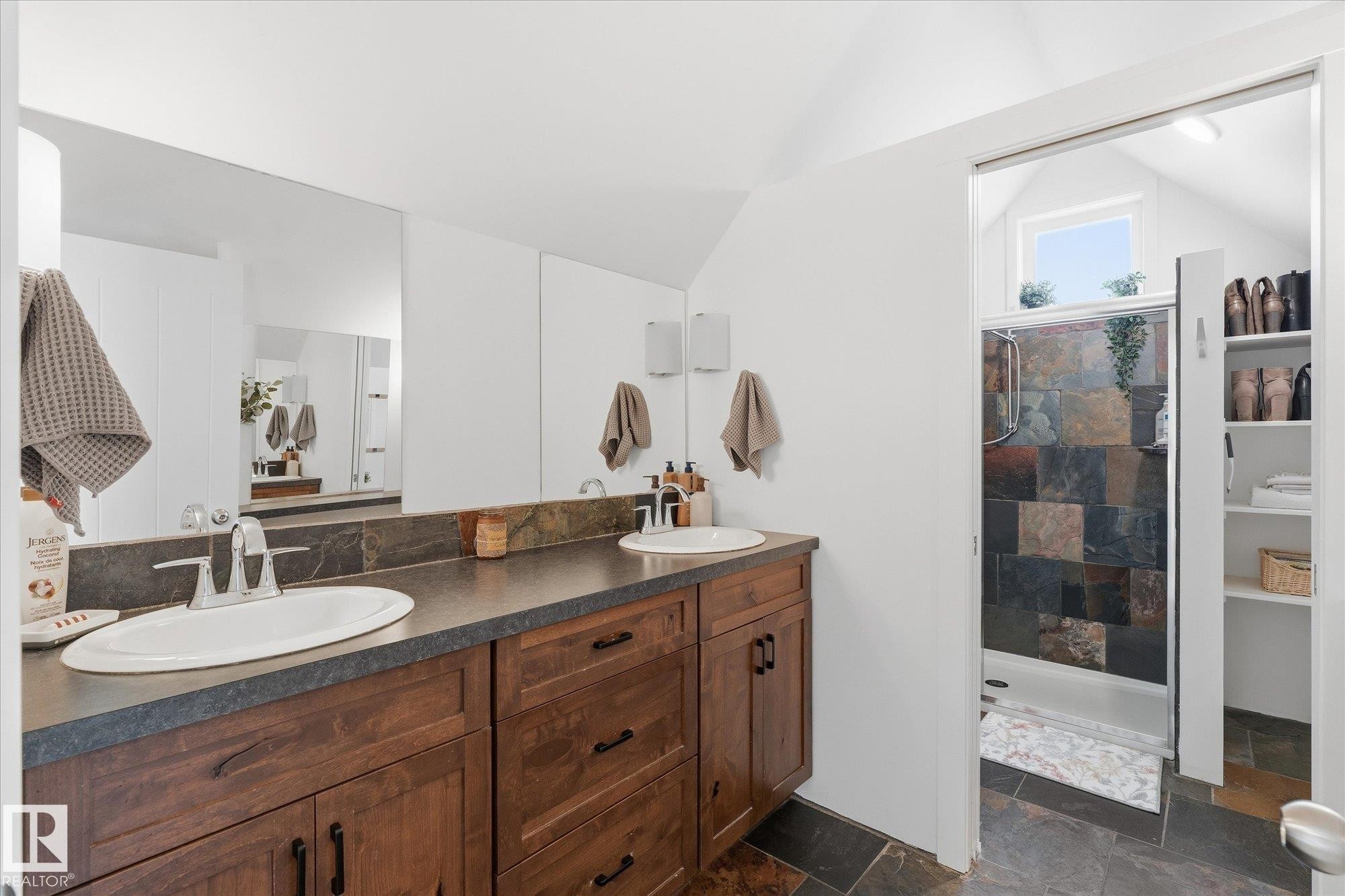 Dual vanity with integrated sinks, wood-finish cabinetry, and a full-width mirror - #45 53122 Rge Road 14, Rural Parkland County, AB