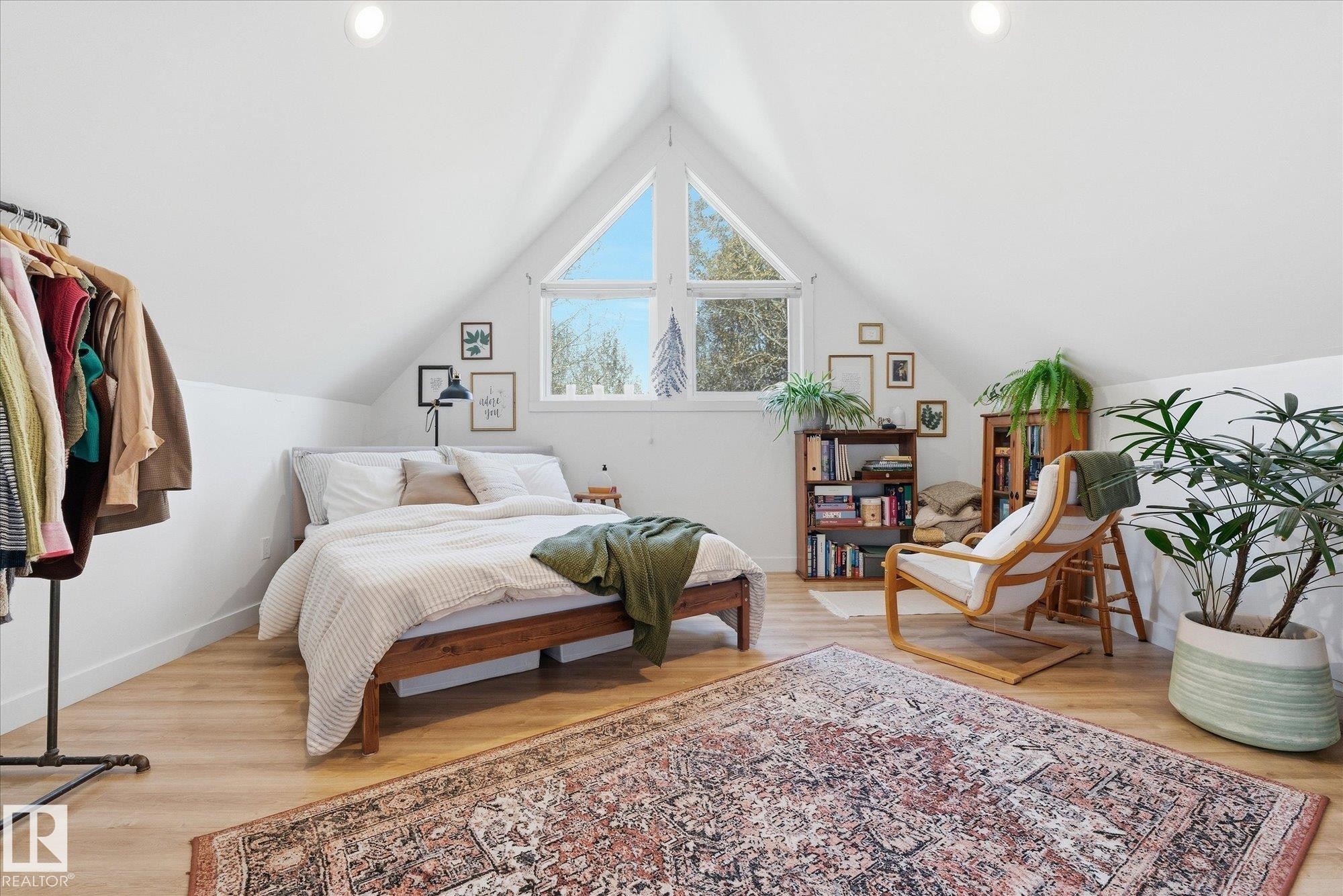 Vaulted white ceilings, wood-finish flooring, a prominent triangular window, recessed lighting, and built-in shelving - #45 53122 Rge Road 14, Rural Parkland County, AB