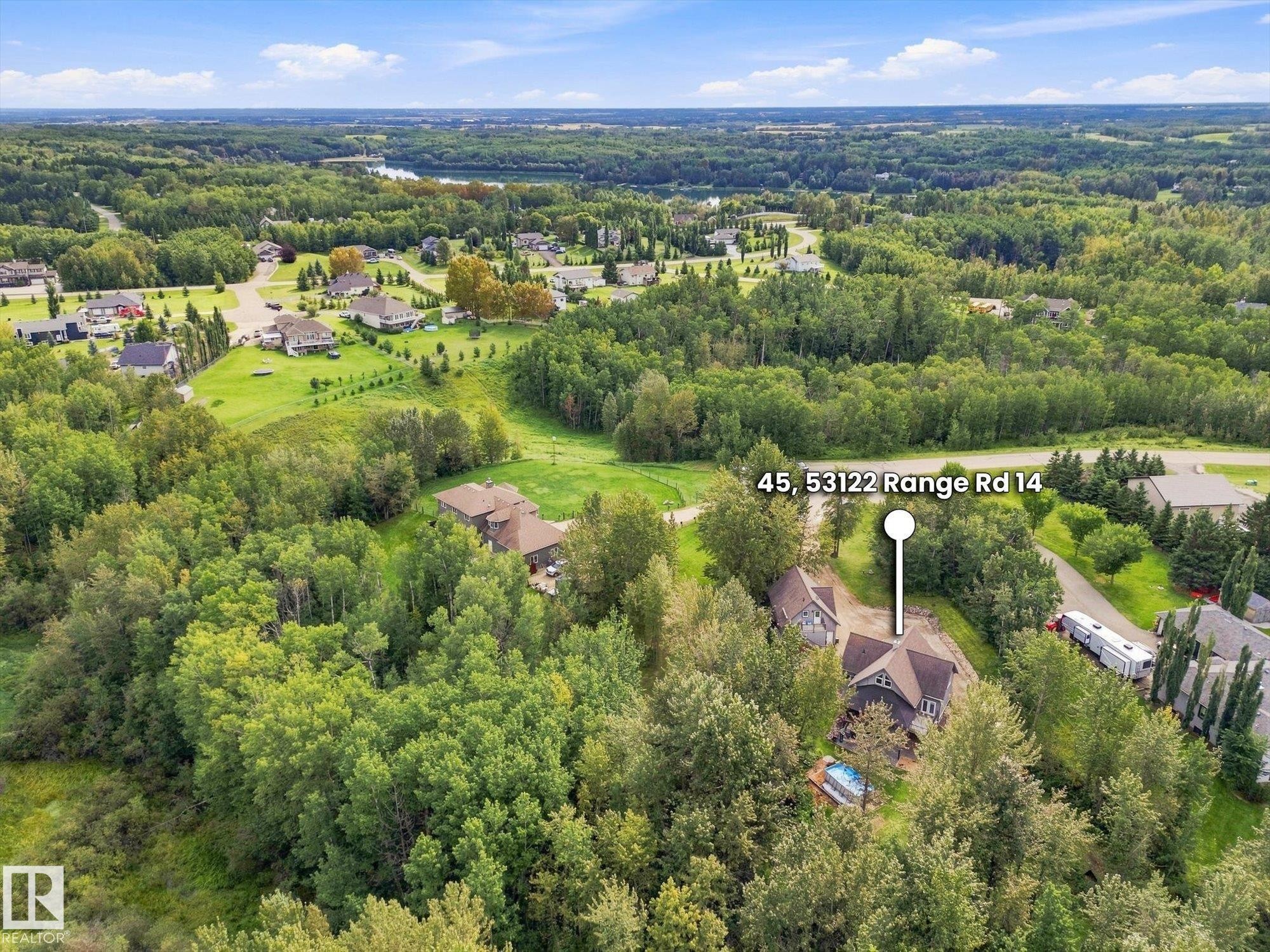 Expansive treed lot featuring a private residence with a dark-toned exterior and a blue above-ground pool - #45 53122 Rge Road 14, Rural Parkland County, AB