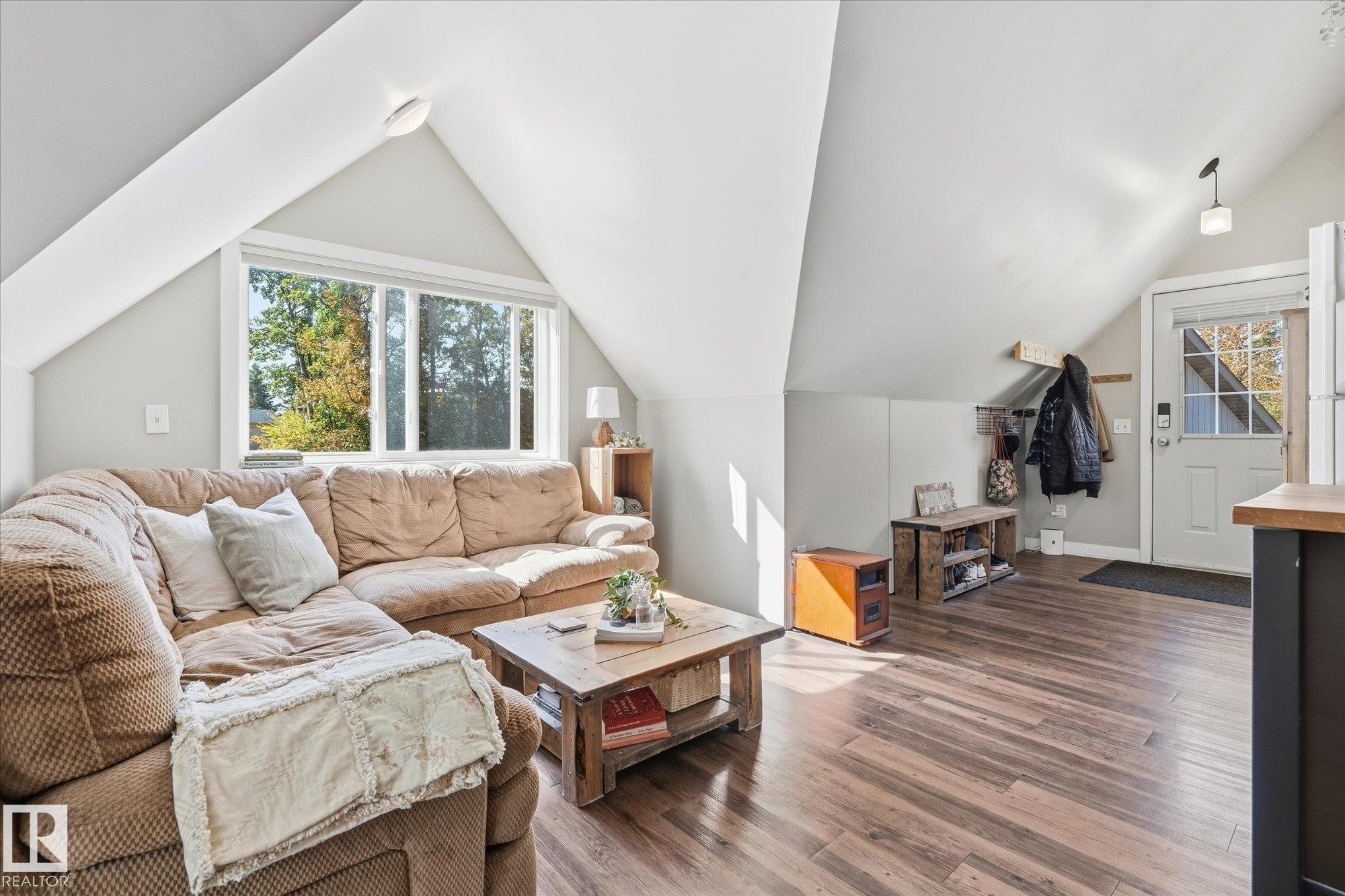 Vaulted ceilings, a wide window, wood-finish flooring, and a white entry door - #45 53122 Rge Road 14, Rural Parkland County, AB