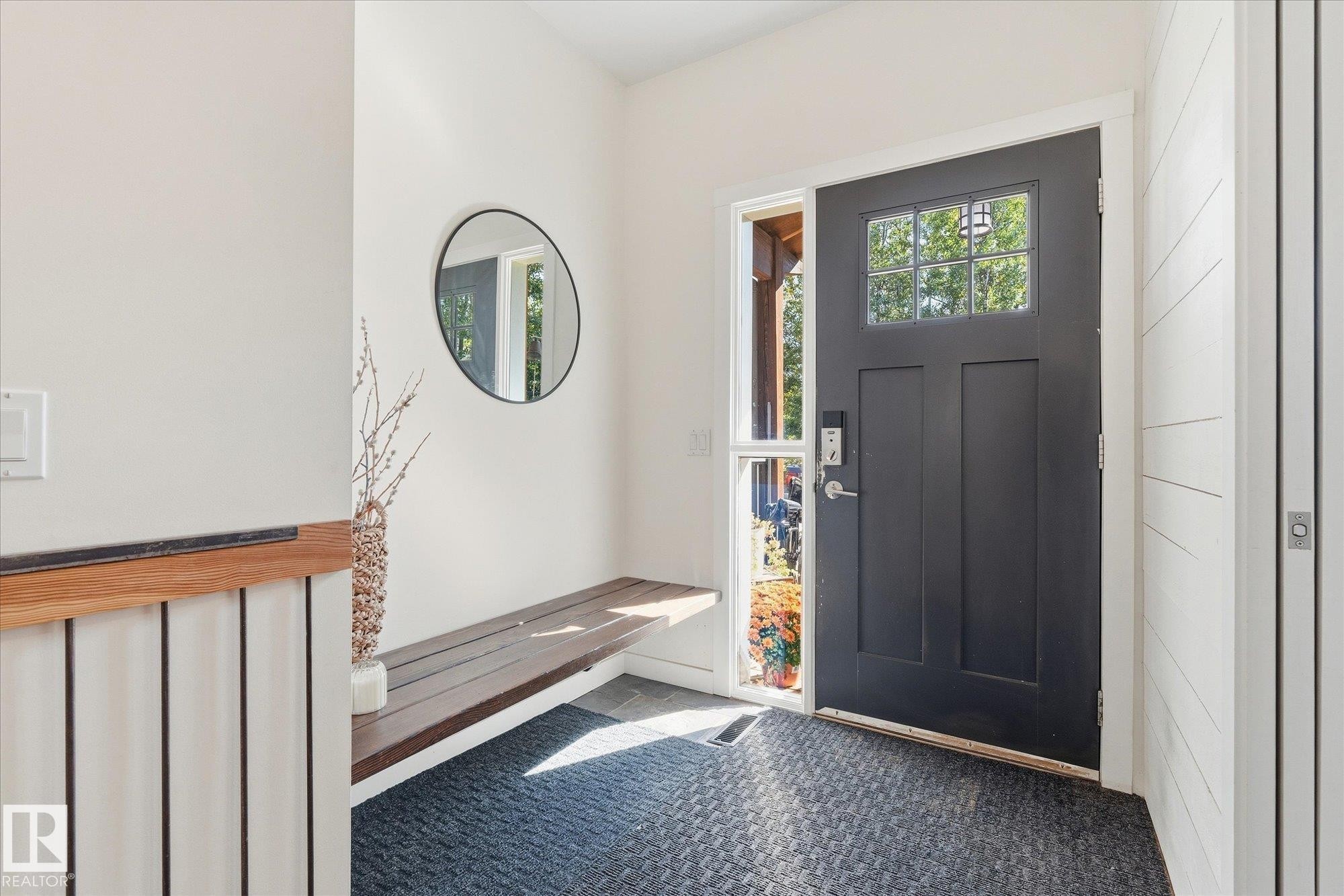 Solid entry door with glass paneling, full-length sidelight, wood-finish built-in bench, and shiplap wall accent - #45 53122 Rge Road 14, Rural Parkland County, AB
