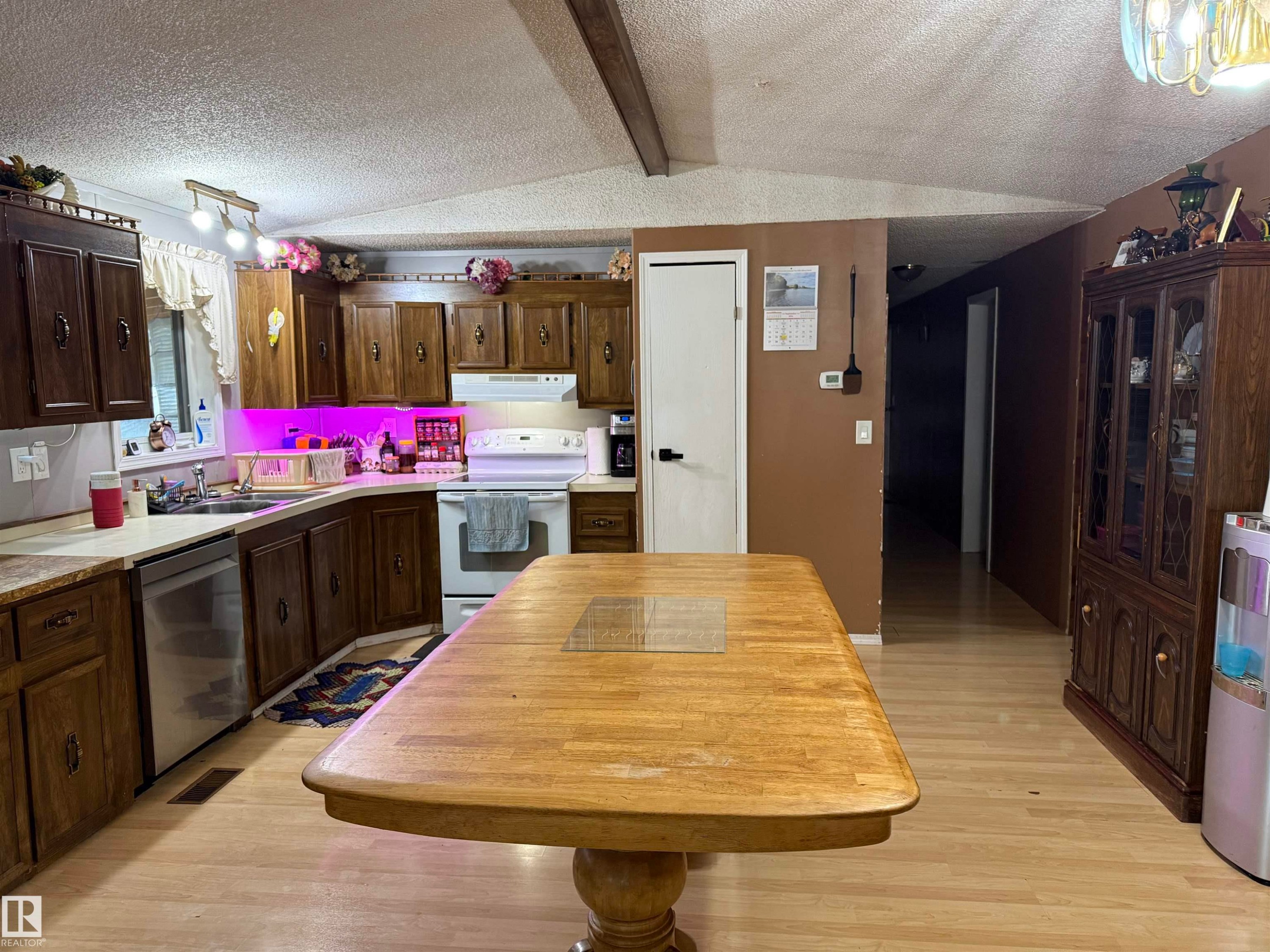 Wood-finish flooring, white countertops, and a white dishwasher - 4626 51 Avenue, Willingdon, AB