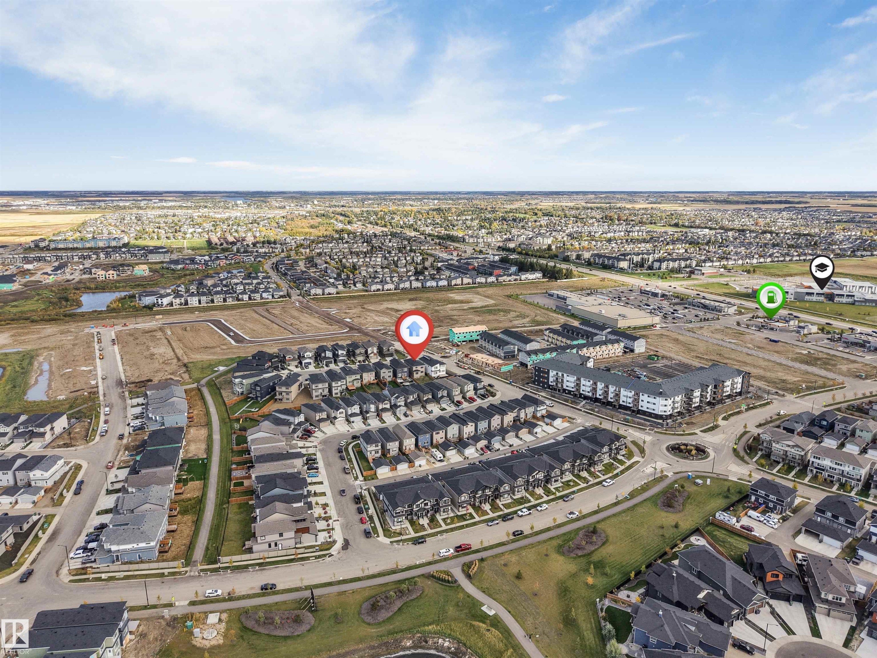 Aerial perspective showcasing residential development, commercial structures, a roundabout, and green spaces - 403 Pine Point, Leduc, AB