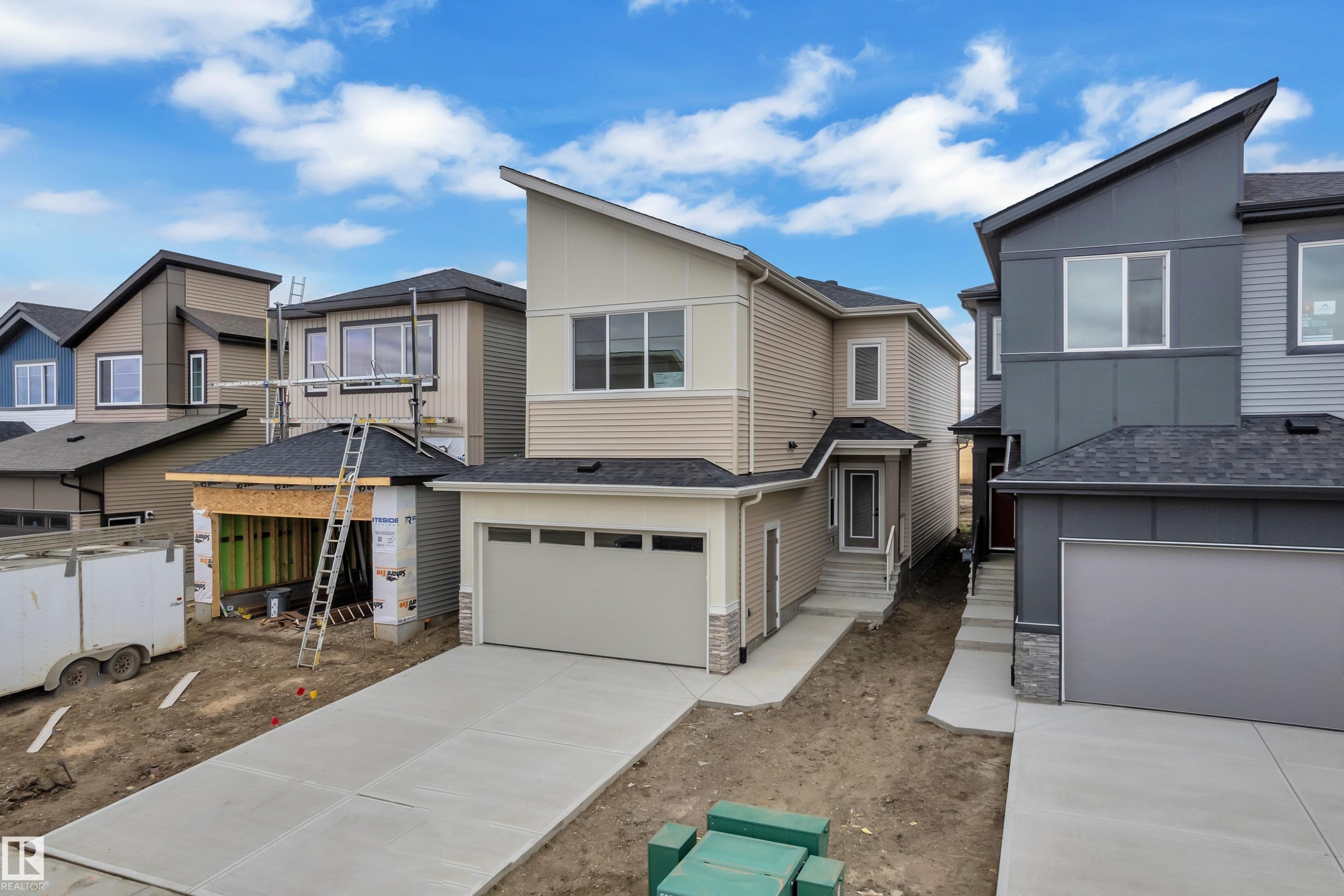 Contemporary exterior with mixed material siding, an attached two-car garage, and a concrete driveway - 794 Bank Drive, Leduc, AB