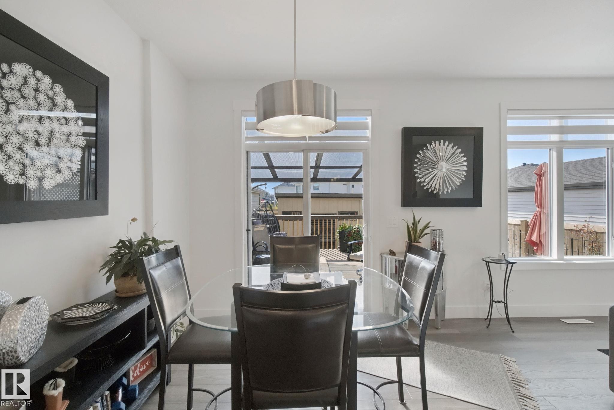White walls, a glass door leading to a deck, and window coverings - 153 Cavanagh Common Sw, Edmonton, AB