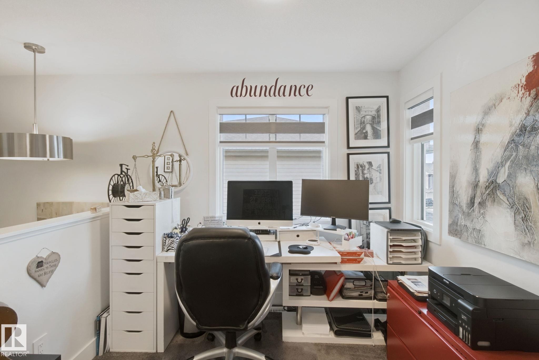 Loft area with a built-in desk, white cabinetry, and multiple windows - 153 Cavanagh Common Sw, Edmonton, AB
