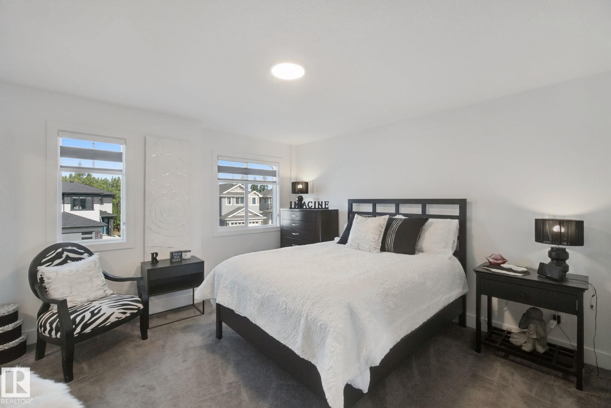Recessed ceiling lighting, two windows, textured wall panel, soft gray carpeting, and white walls - 153 Cavanagh Common Sw, Edmonton, AB