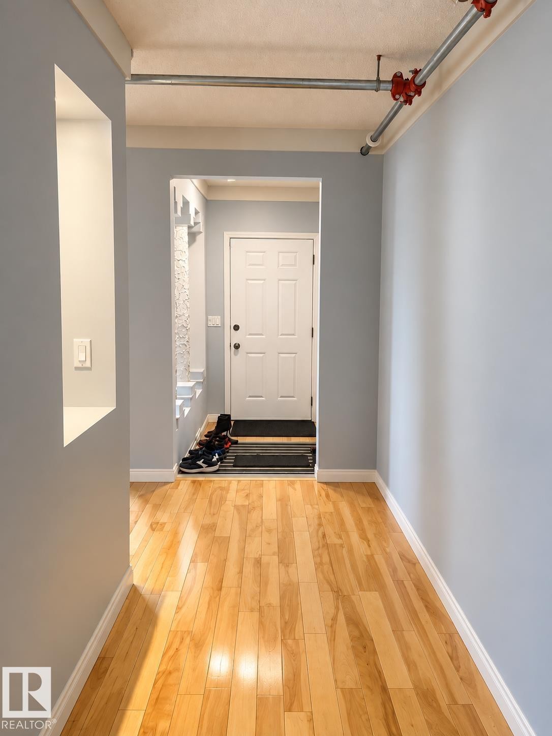 Hardwood flooring with light blue wall paint, white trim, and a built-in wall niche - 18929 99A Avenue Nw, Edmonton, AB