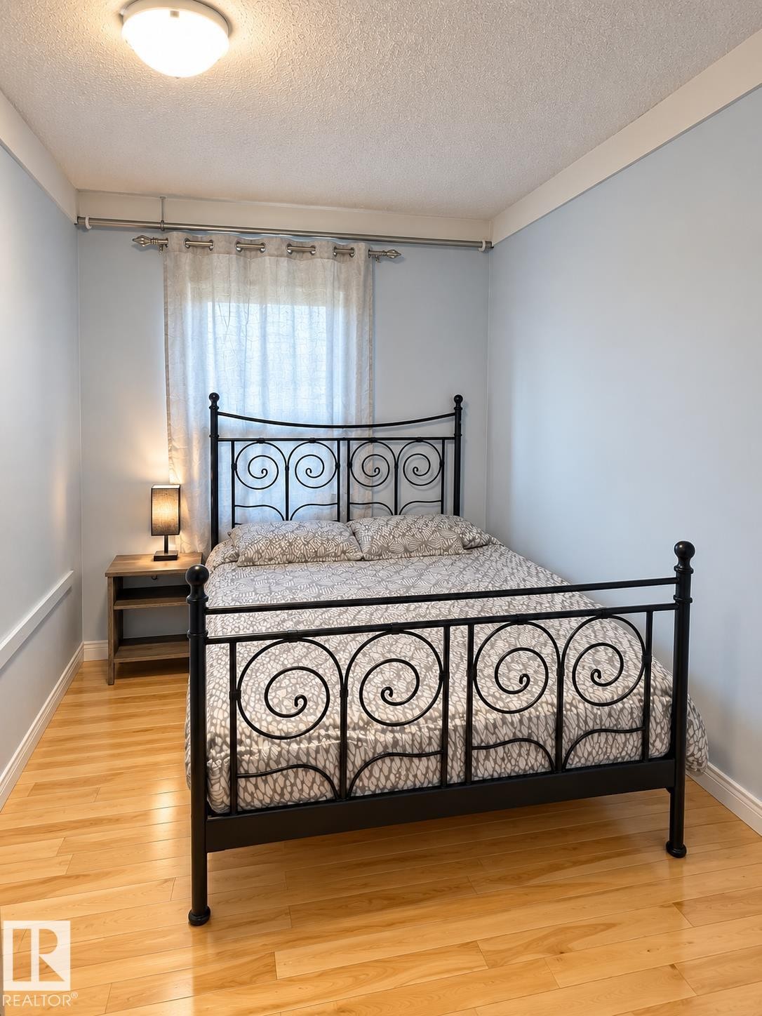 Hardwood flooring, light blue wall paint, ceiling-mounted light fixture, and window with natural light - 18929 99A Avenue Nw, Edmonton, AB