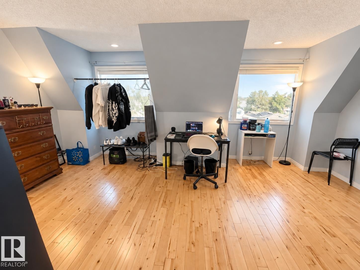 Room featuring wood-finish flooring, recessed lighting, and sloped ceilings with integrated windows - 18929 99A Avenue Nw, Edmonton, AB