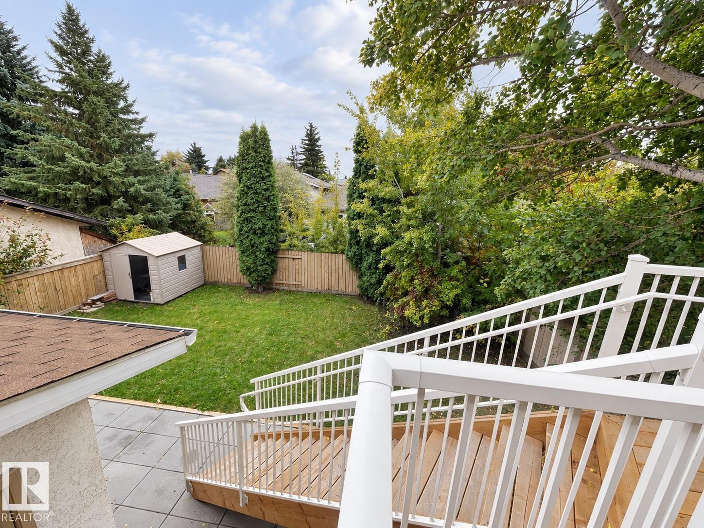 Expansive backyard featuring a manicured lawn, wood fencing, and mature trees - 18929 99A Avenue Nw, Edmonton, AB