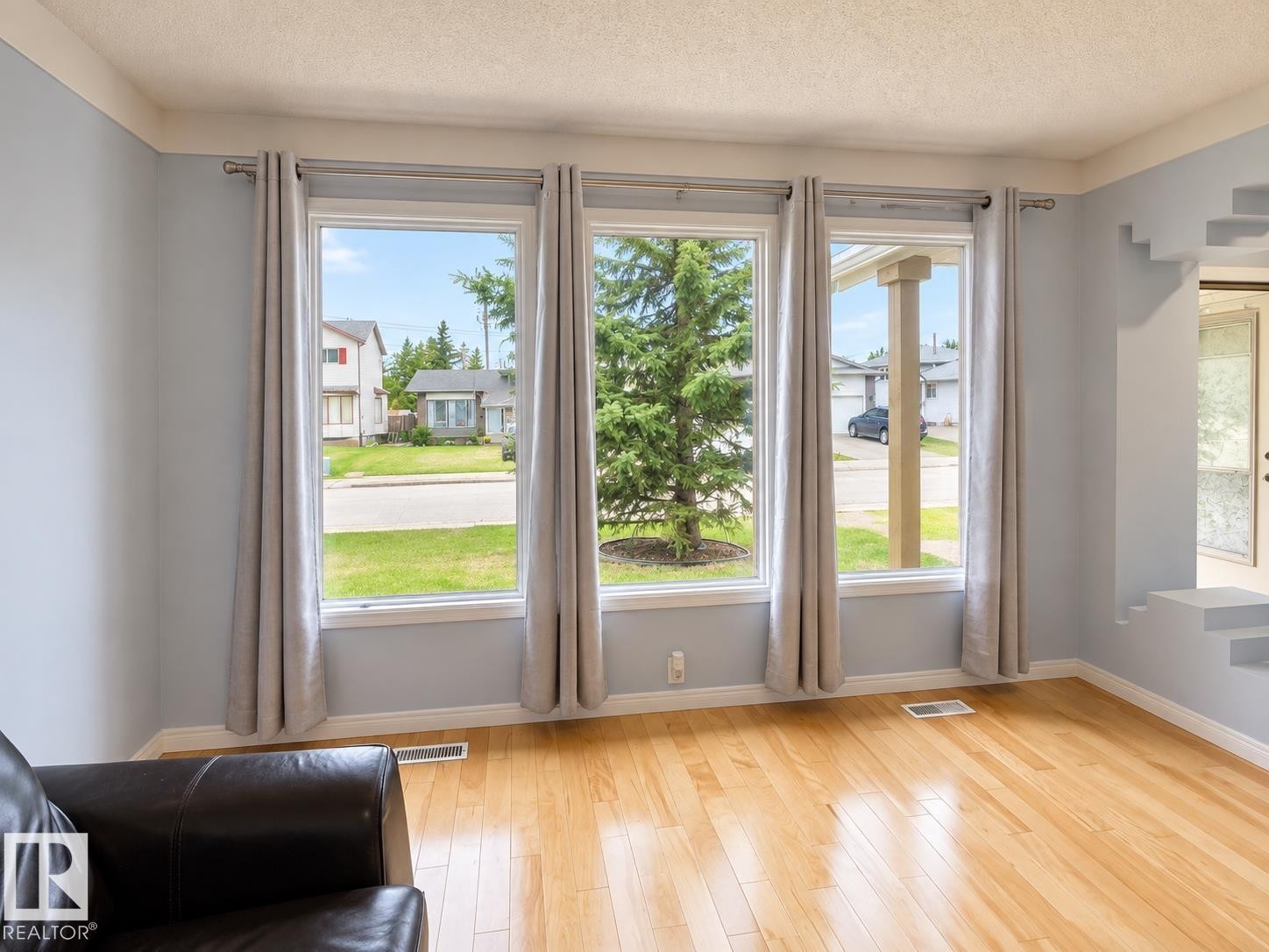 Hardwood flooring, light blue wall paint, multiple large windows, white window frames, and crown molding - 18929 99A Avenue Nw, Edmonton, AB